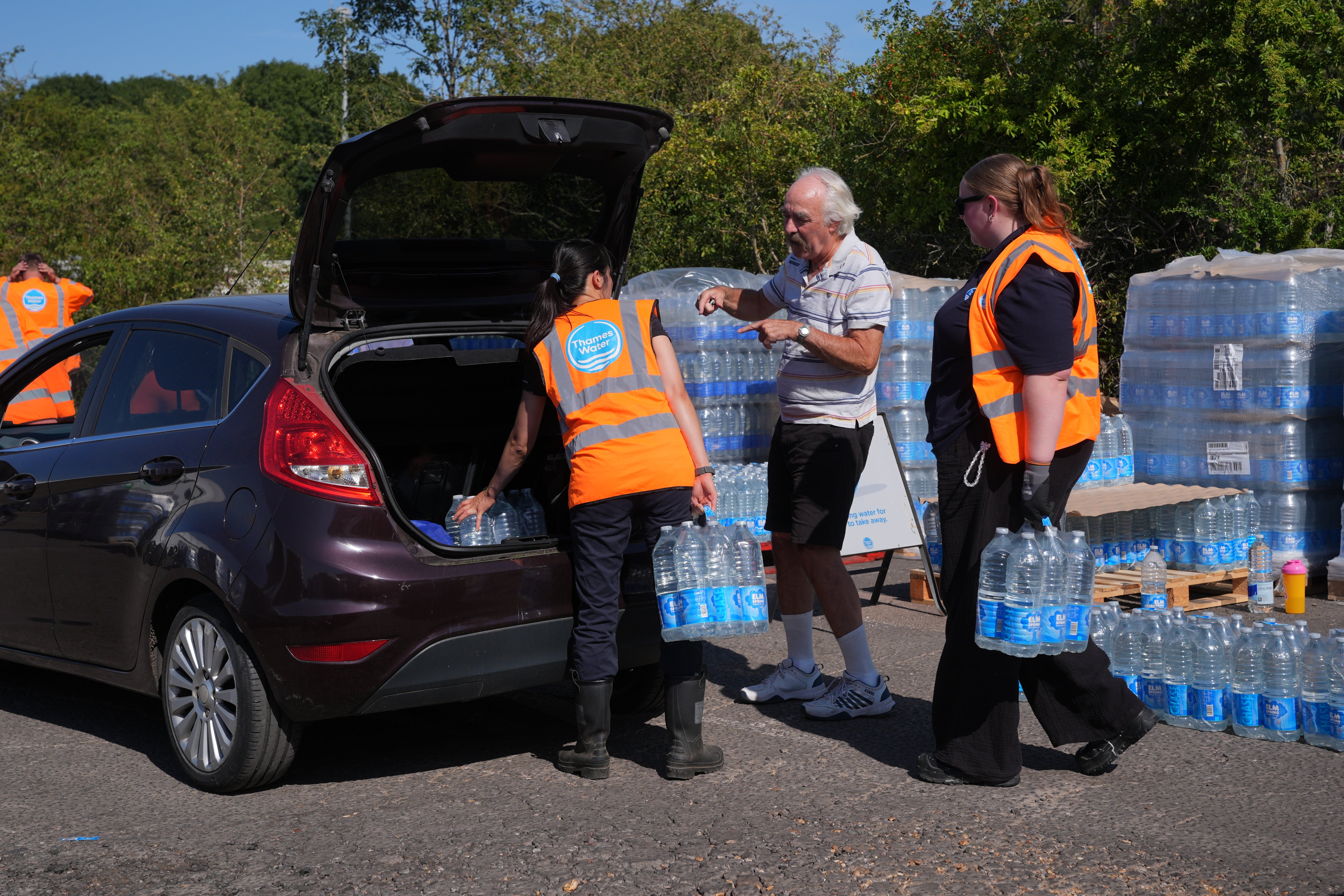 Thames Water personnel handing out bottled water to residents at Roding Sports Centre in Chigwell, Essex, following a water main burst on Chigwell Road in South Woodford