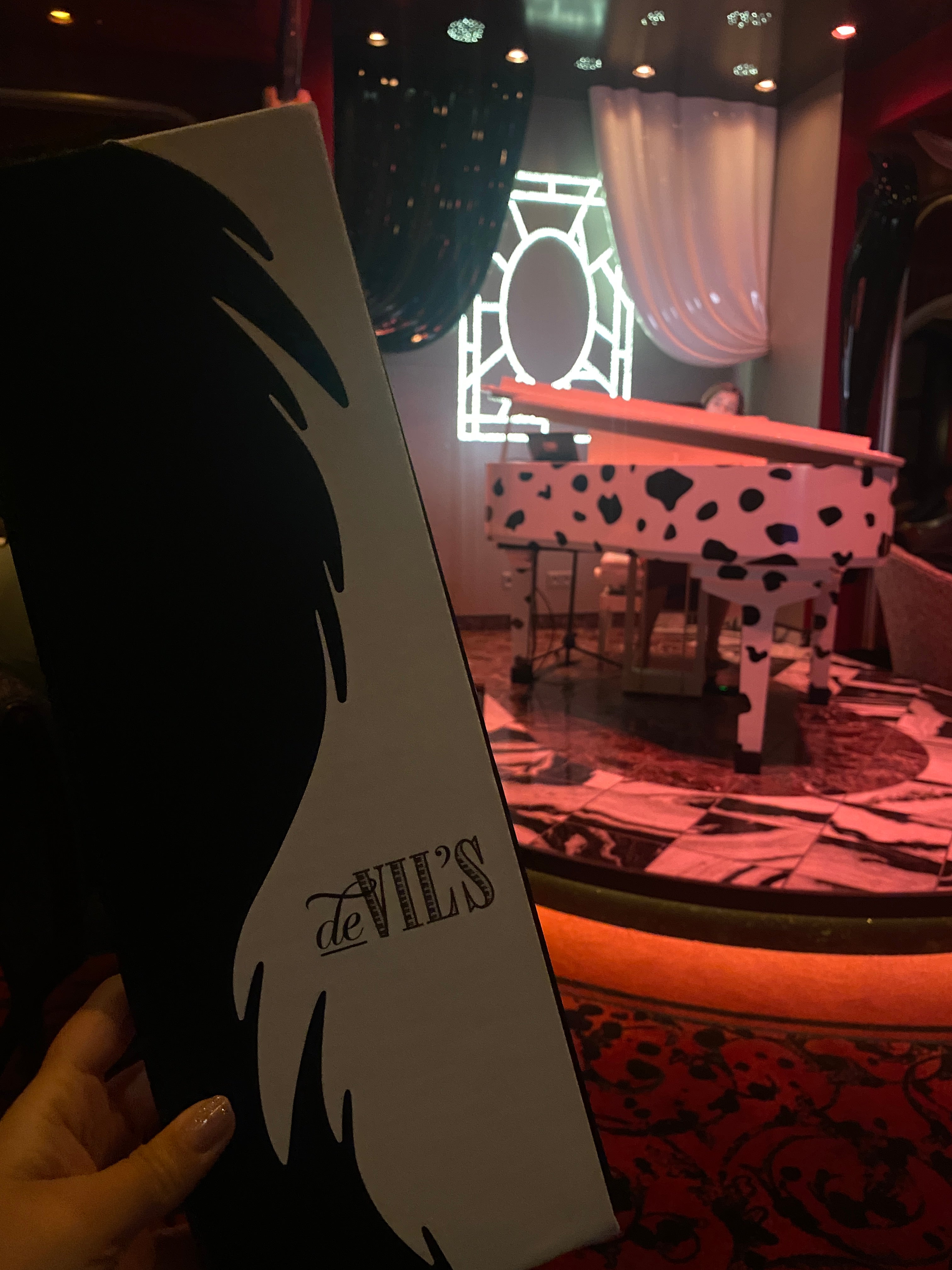 Nearly every detail in De Vil’s references ‘101 Dalmatians,’ from the monochrome décor and spotted piano to themed cocktails and playful touches throughout the room