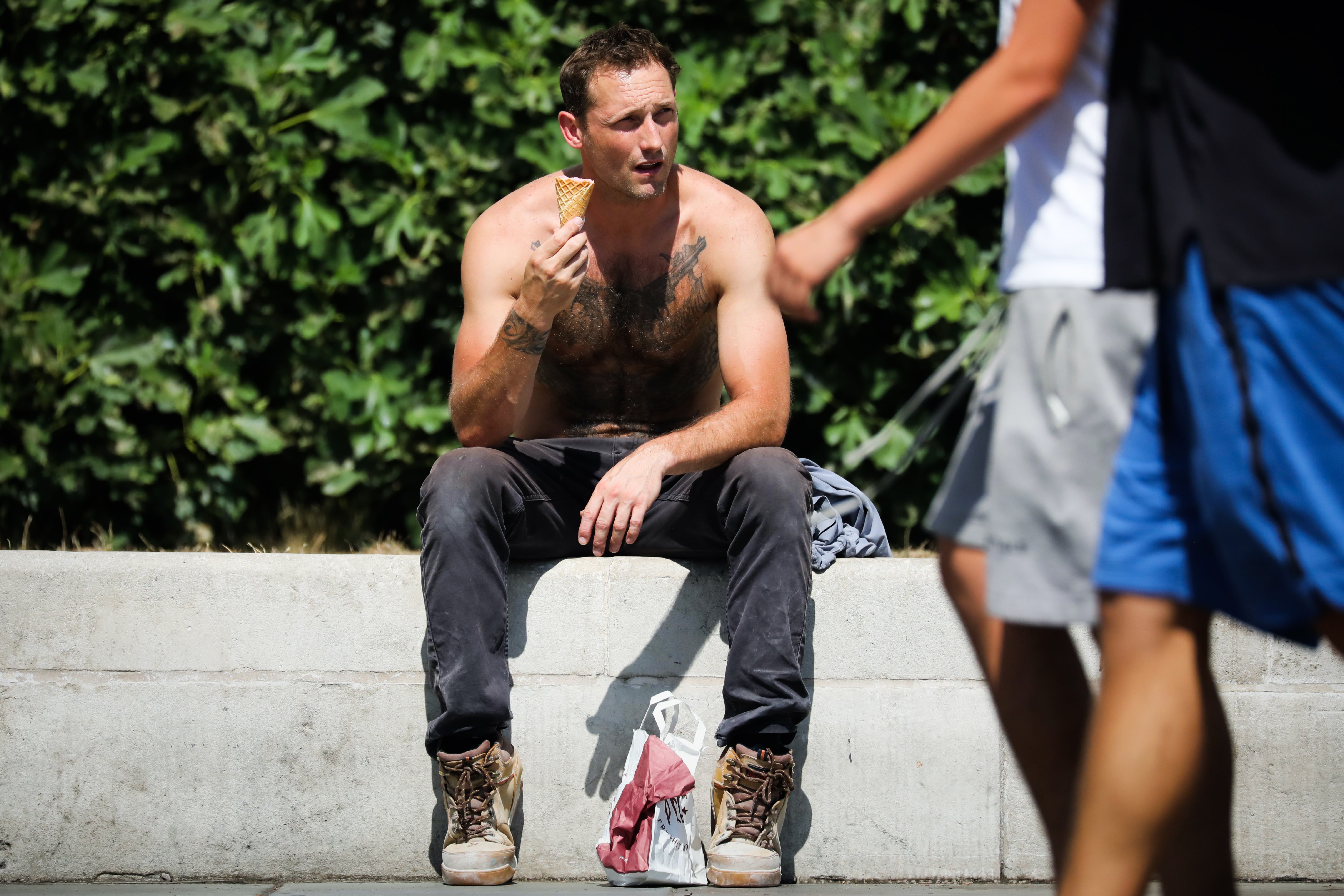 A person eats an ice cream in Trafalgar Square