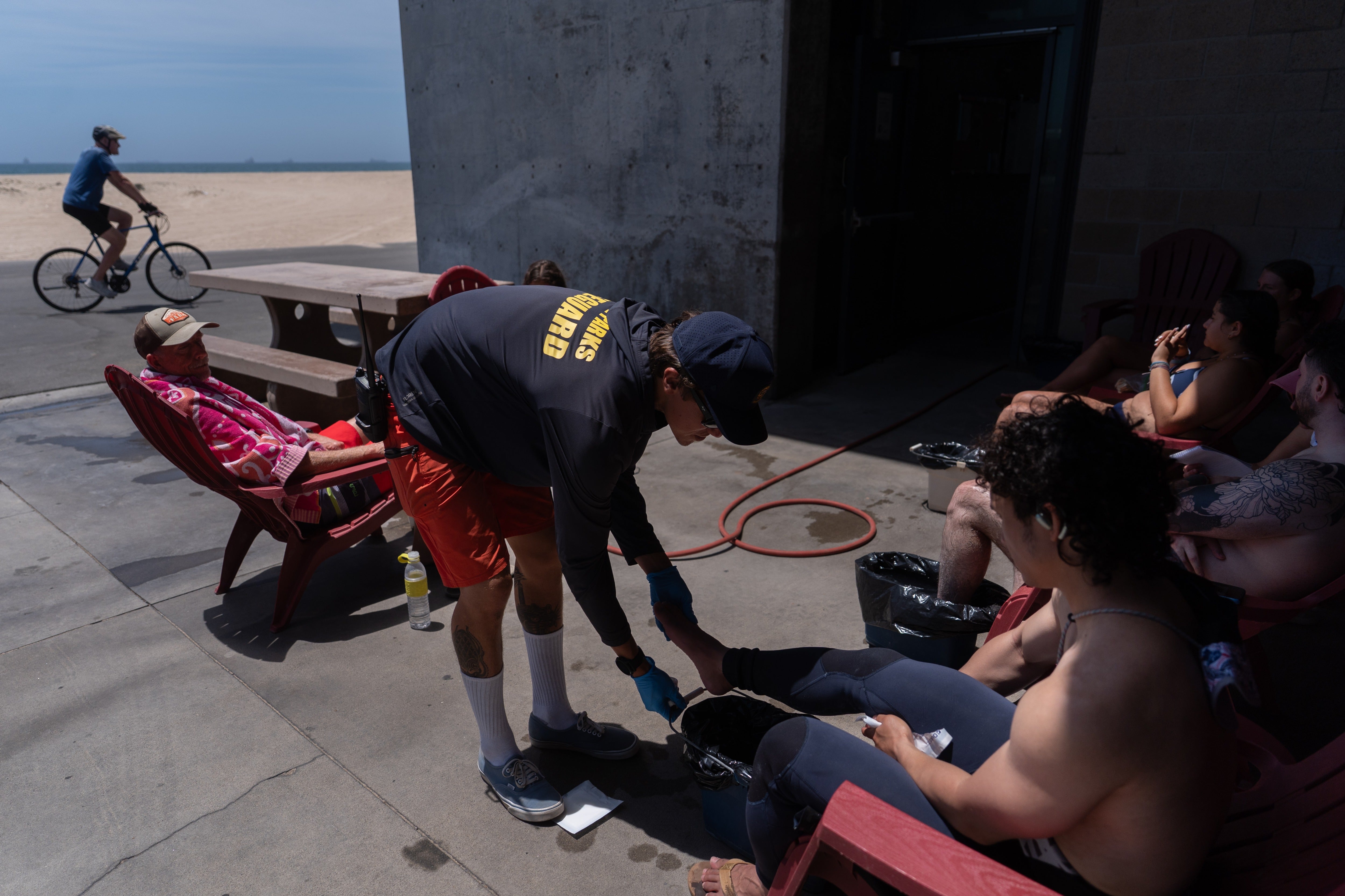 Lifeguard Max Voci treats beachgoers for stingray stings at Bolsa Chica State Beach in Huntington Beach