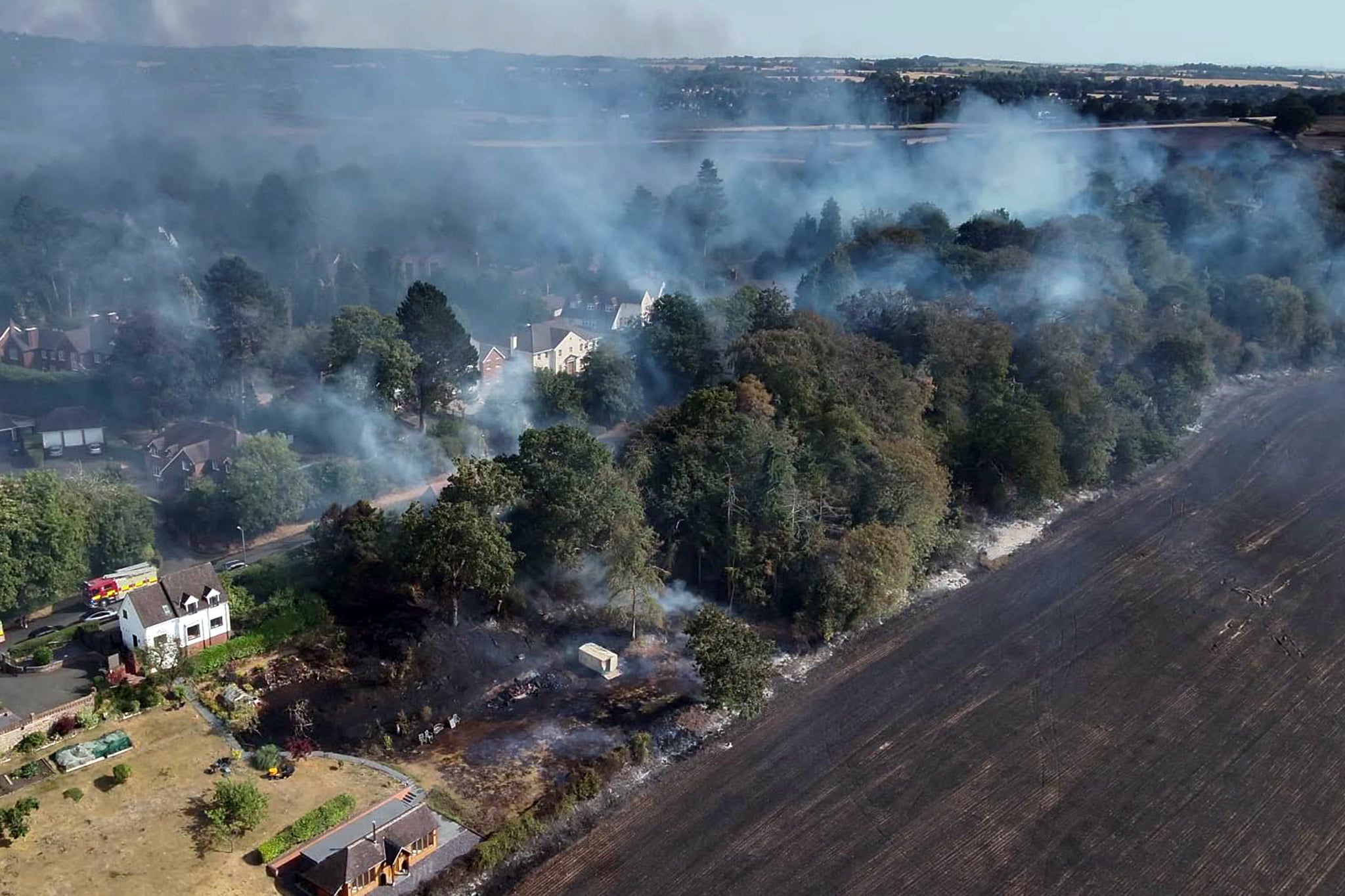 Drone video shared by the service showed a thermal map of flames threatening nearby homes as heavy smoke drifted over the town