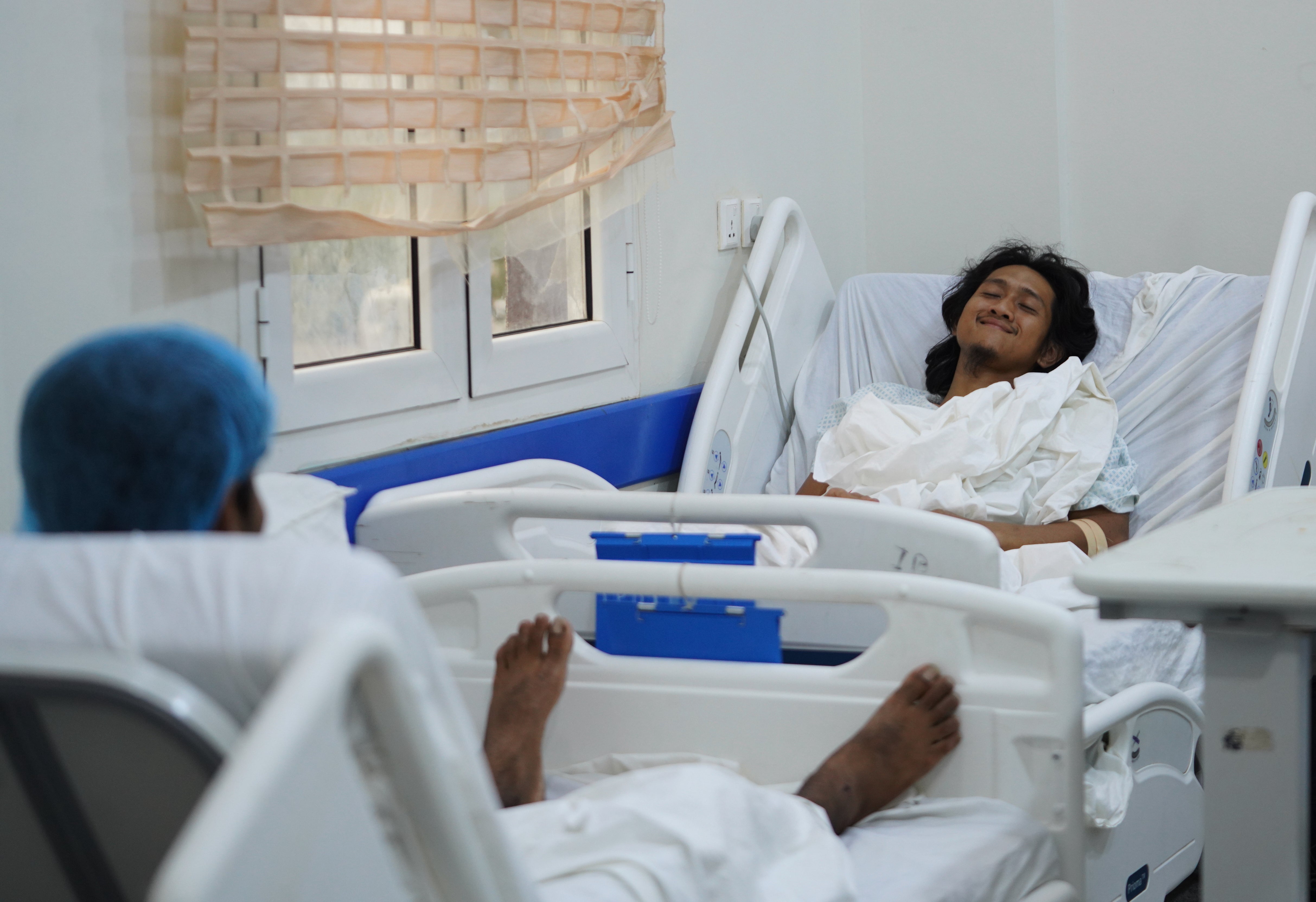 Indonesian crew member Muhammad Al Taindo , right, receives medical treatment after the cargo ship Tihama was struck in a Houthi attack in the Bab al-Mandab Strait