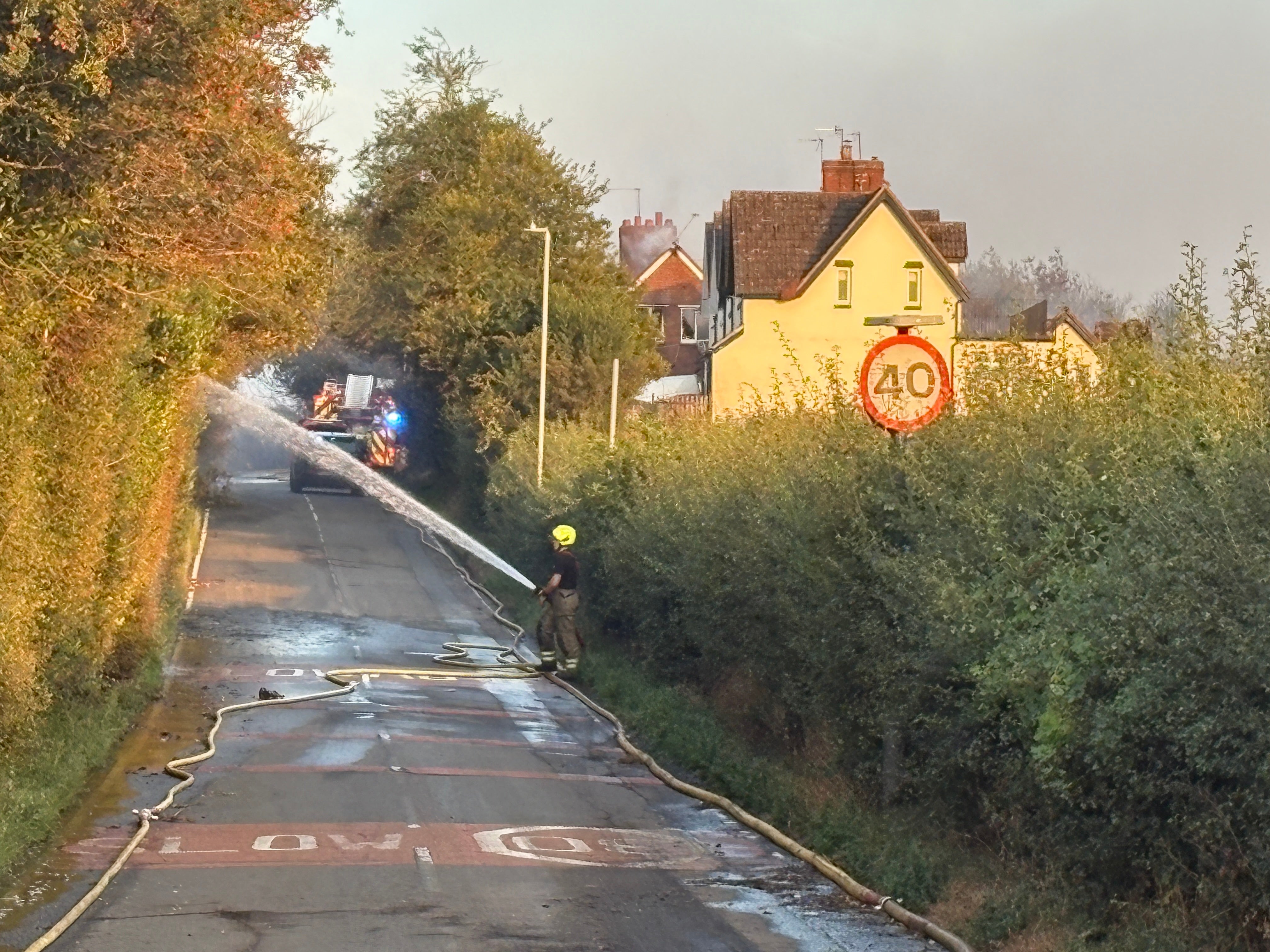 Fire crews working on Racecourse Lane, Stourbridge, near properties damaged by a major fire