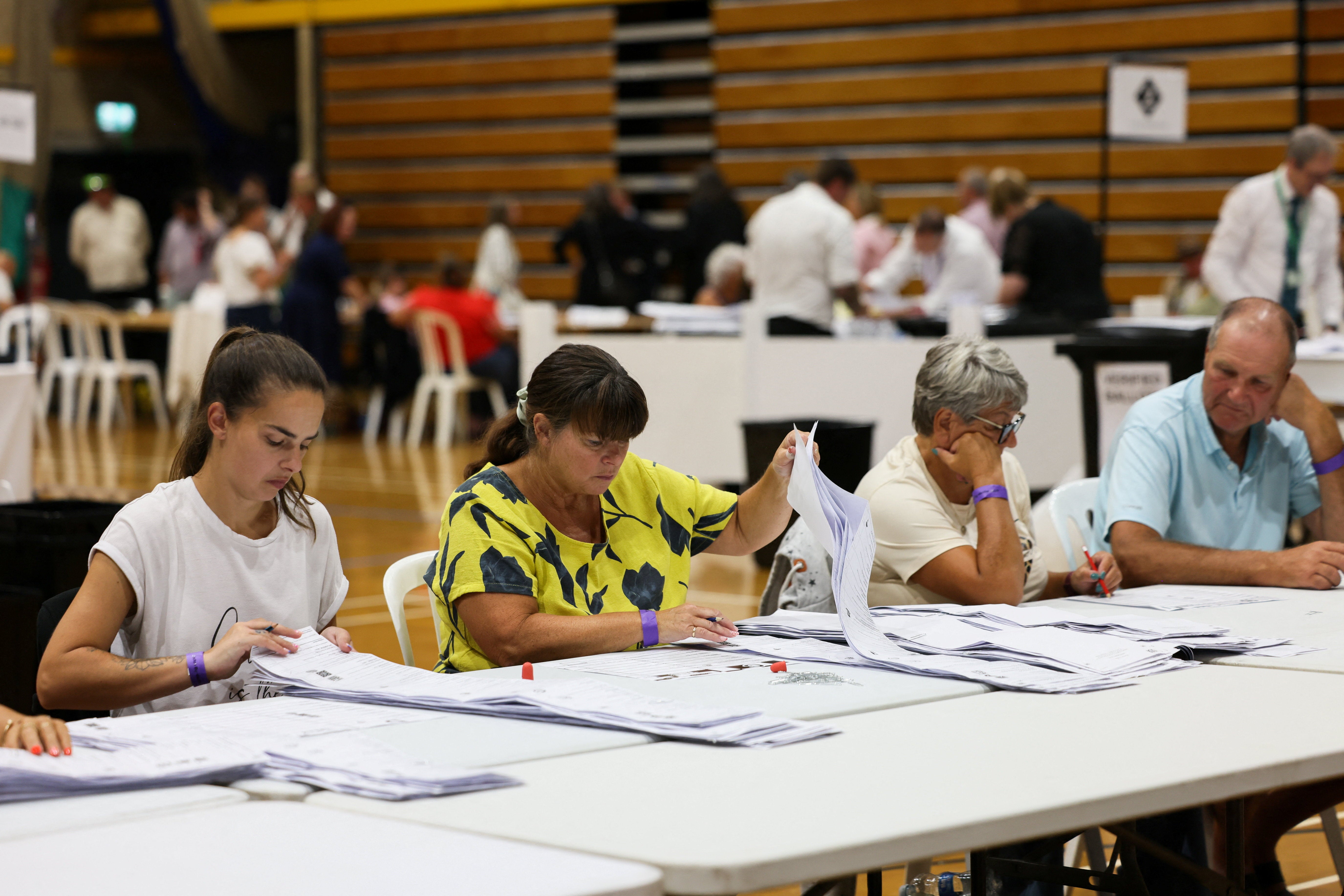 Election workers go through ballots during the vote counting for the Clacton by-election, triggered by Britain's Reform UK party leader Nigel Farage's resignation, at Clacton Leisure Centre in Essex, Britain, 14 August 2026 (Reuters)