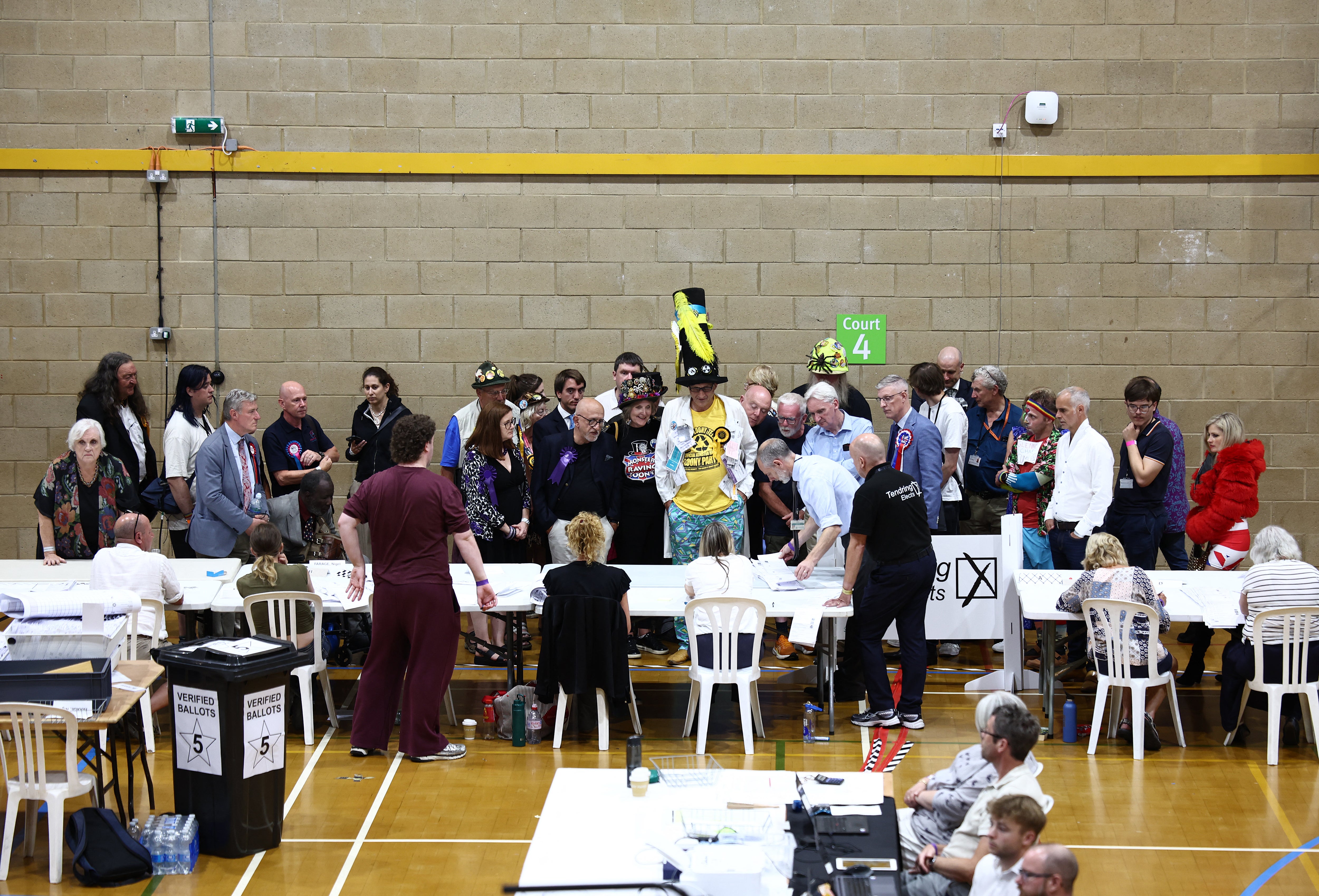 Candidates and election officials watch as counters count votes on ballot papers, during the Clacton by-election count, at Clacton Leisure Centre, eastern England on 14 August 2026 (AFP/Getty)