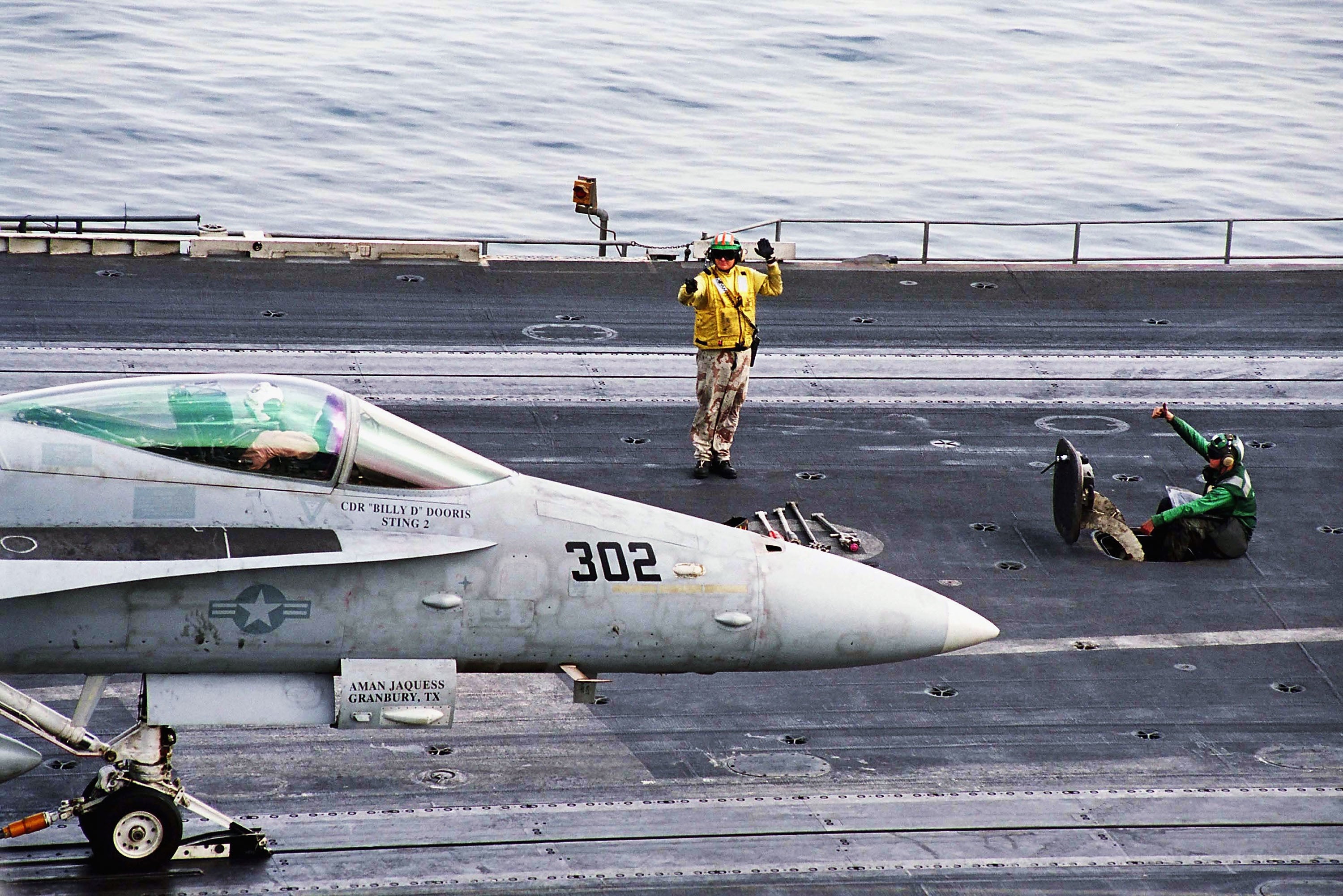 A flight director signals the pilot of a F/A-18C Hornet before take off from one of four steam powered catapults on the flight deck aboard USS Abraham Lincoln (CVN 72) April 1, 2003 in the Arabian Gulf