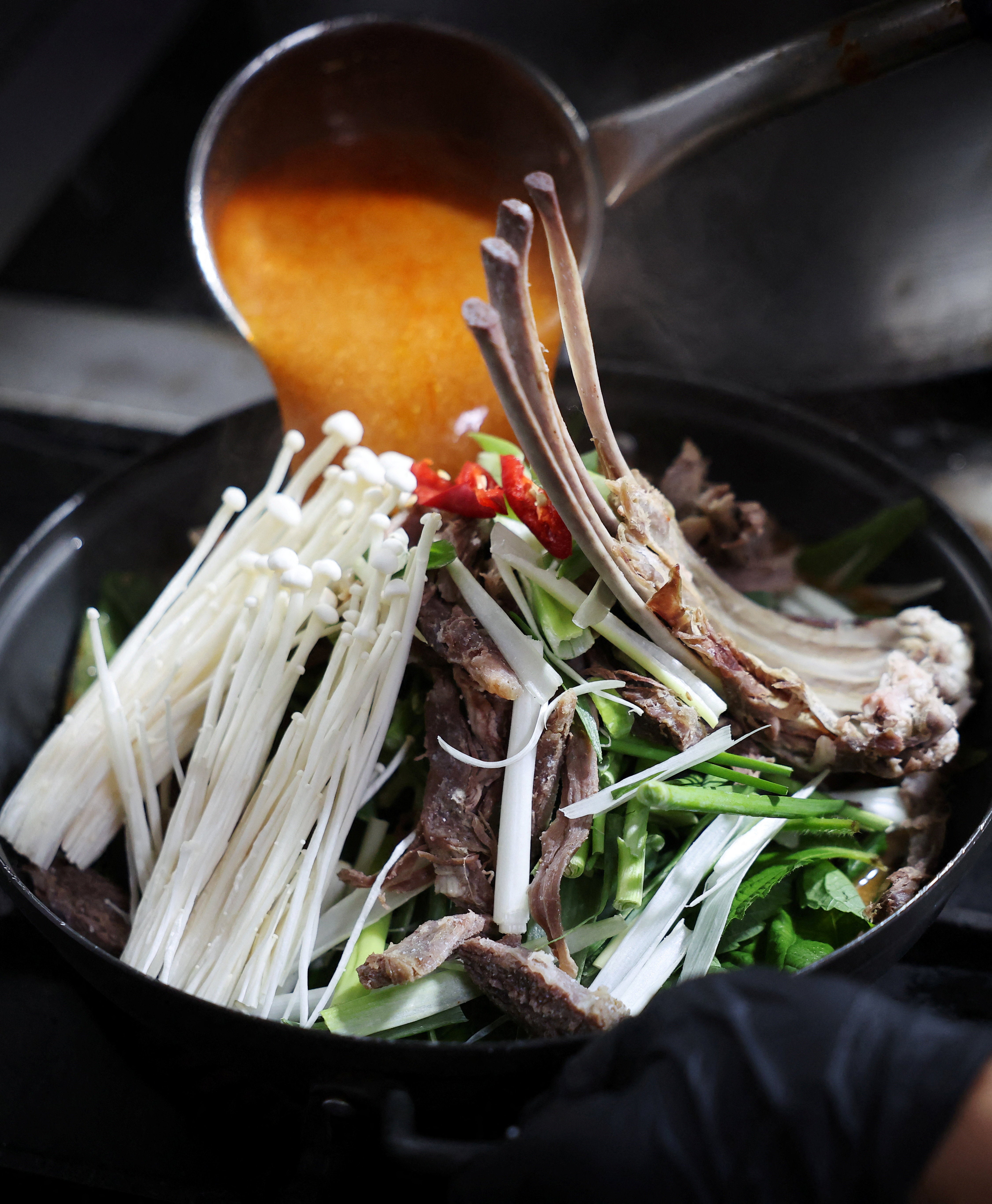 An employee cooks a black goat meat stew during Malbok, the last of Korea's traditional hottest days of summer