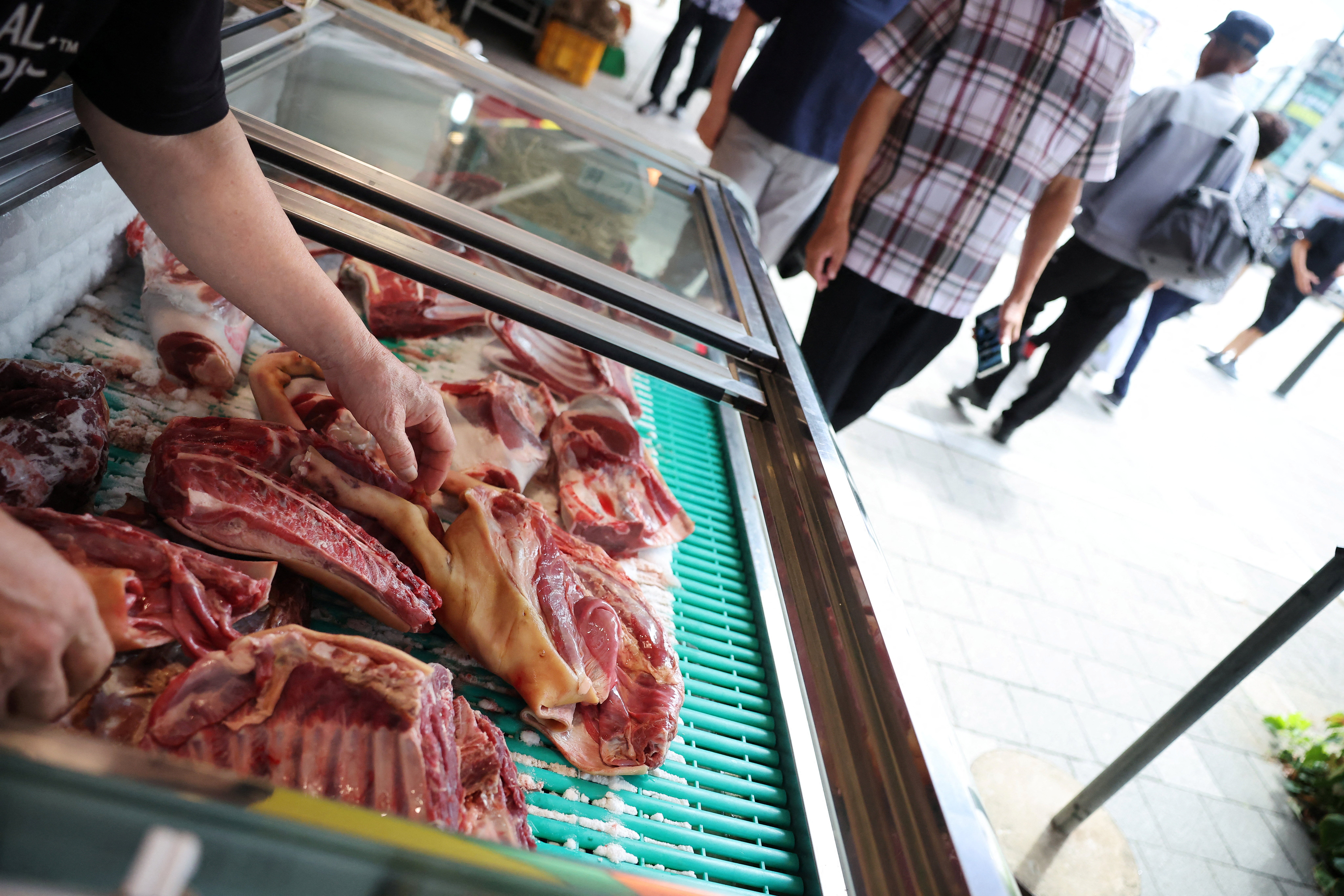 An employee displays chopped dog meat for sale during Malbok, the last of Korea's traditional hottest days of summer, at a restaurant selling dog meat and black goat meat stews in Seongnam, South Korea, August 14