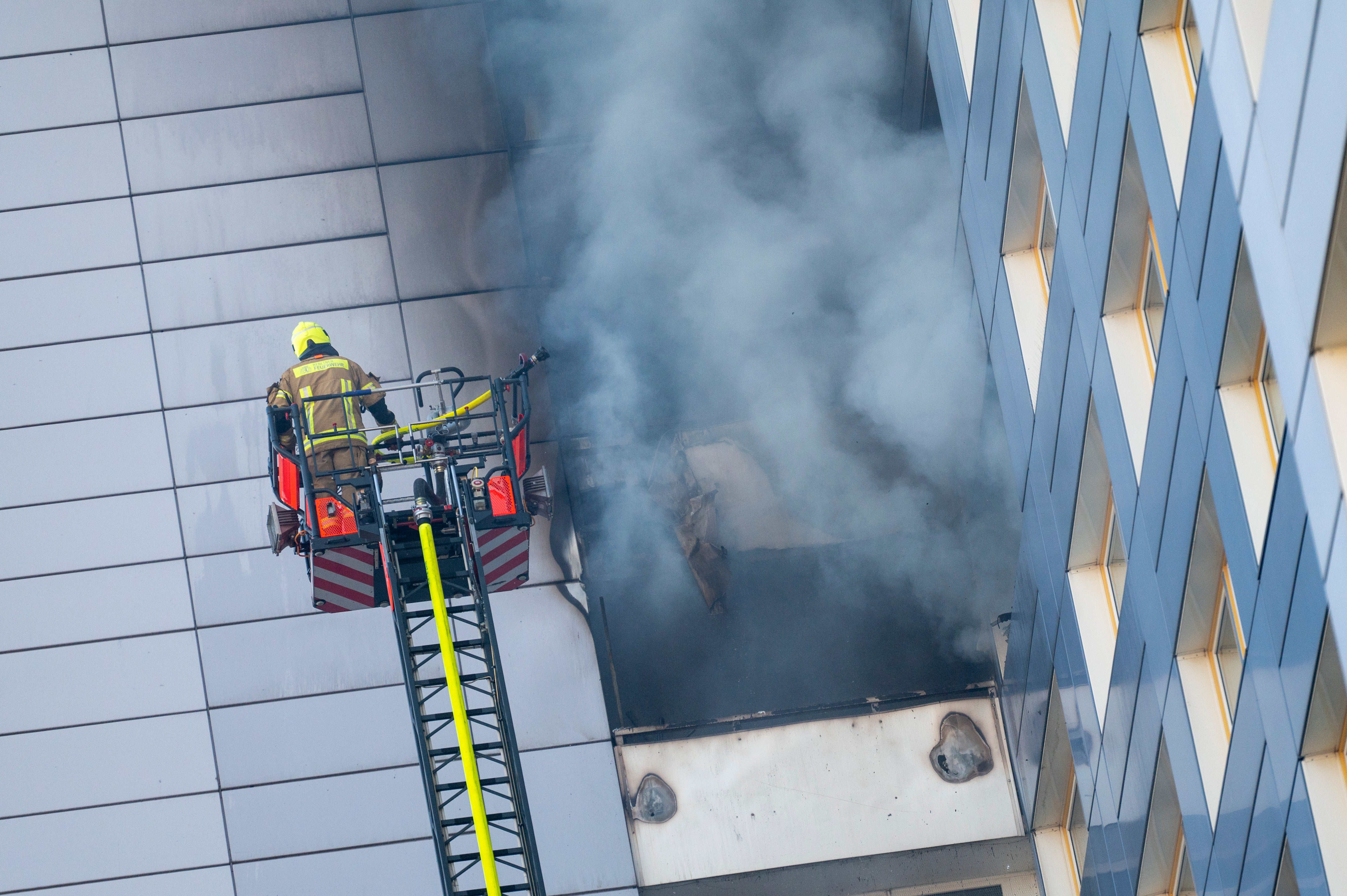 Firefighters work at extinguishing a fire in a high-rise building, in Friedrichshain, Berlin, Friday, Aug. 14, 2026, (Christophe Gateau/dpa via AP)