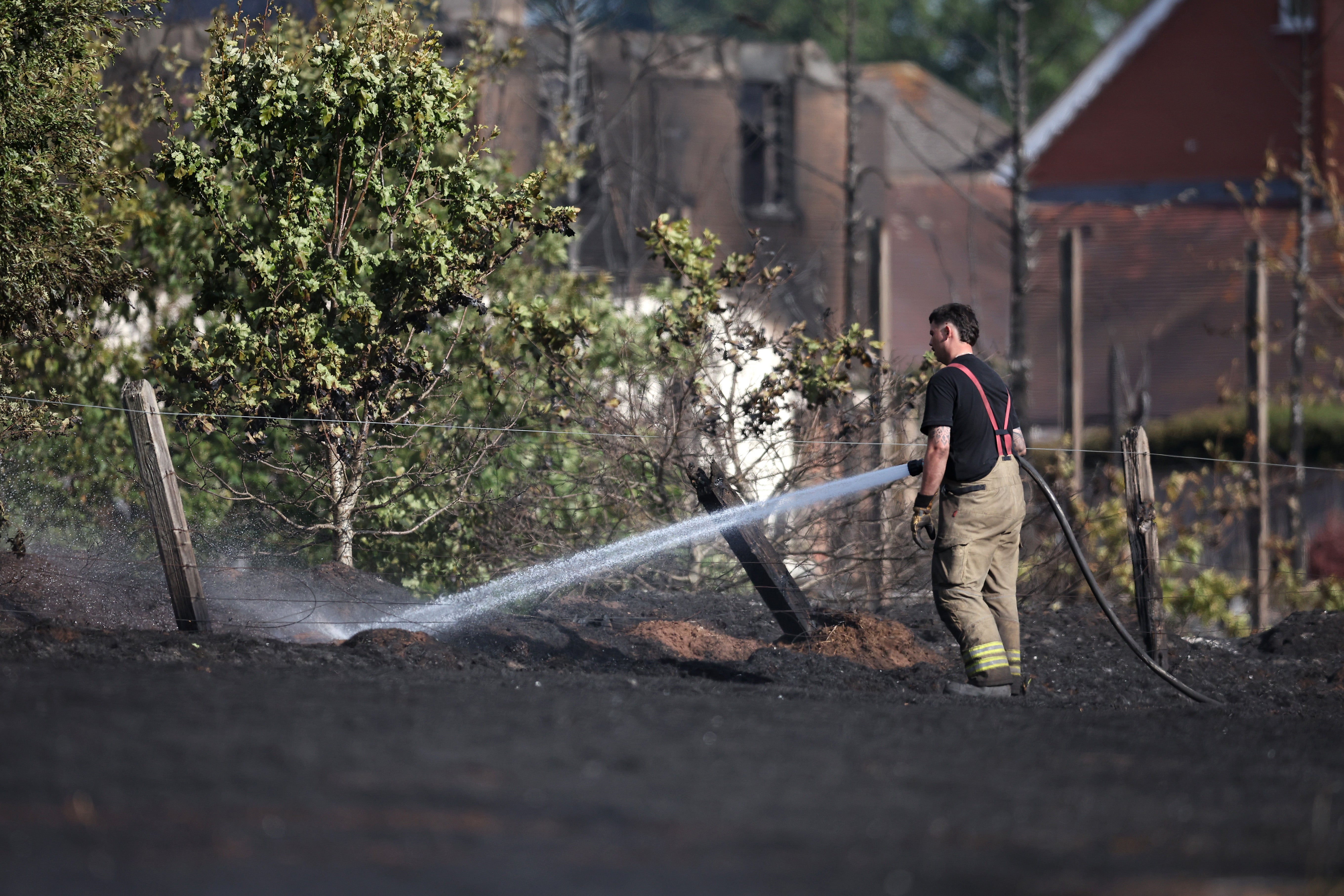 There have been several wildfires this summer, including in the West Midlands. Here, emergency services attend the scene near the burnt out remains of homes following a huge fire in Stourbridge (Getty)
