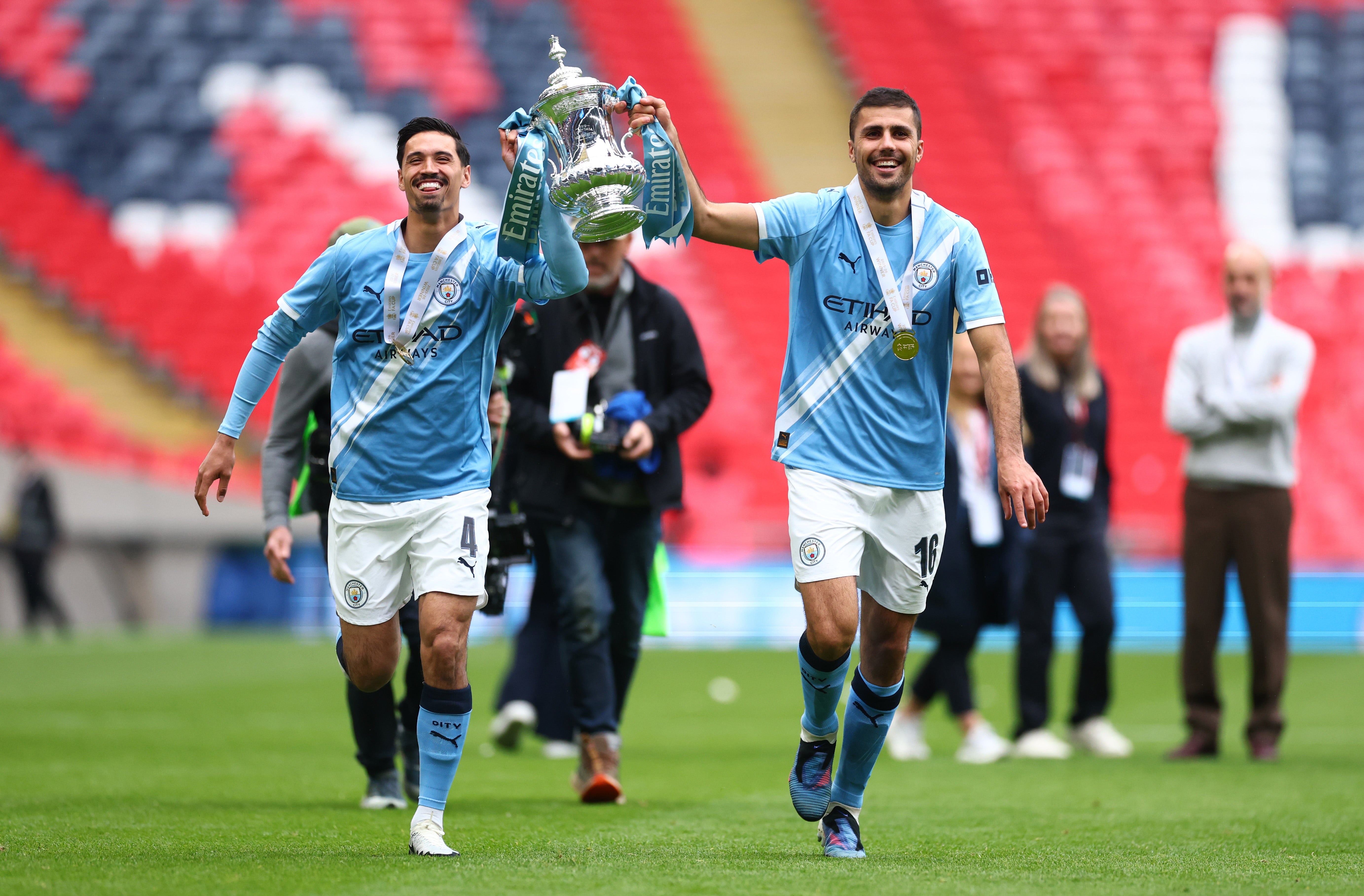 Tijjani Reijnders, left, celebrates with the FA Cup