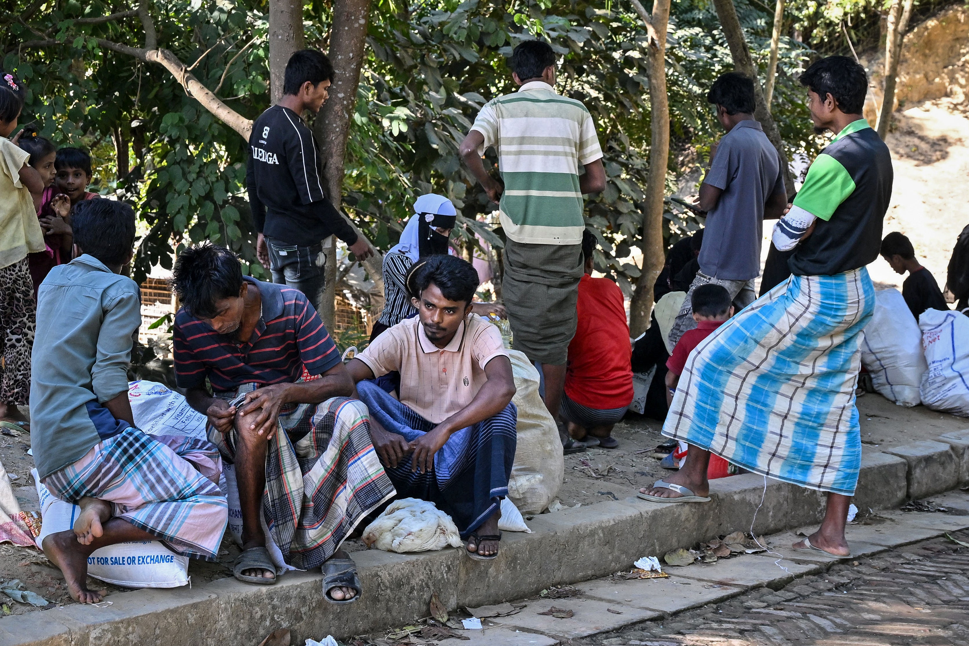 Rohingya refugees wait outside a distribution centre after collecting relief materials at the Kutupalong camp in Cox’s Bazar, Bangladesh, on 20 December 2025 (AFP/Getty)