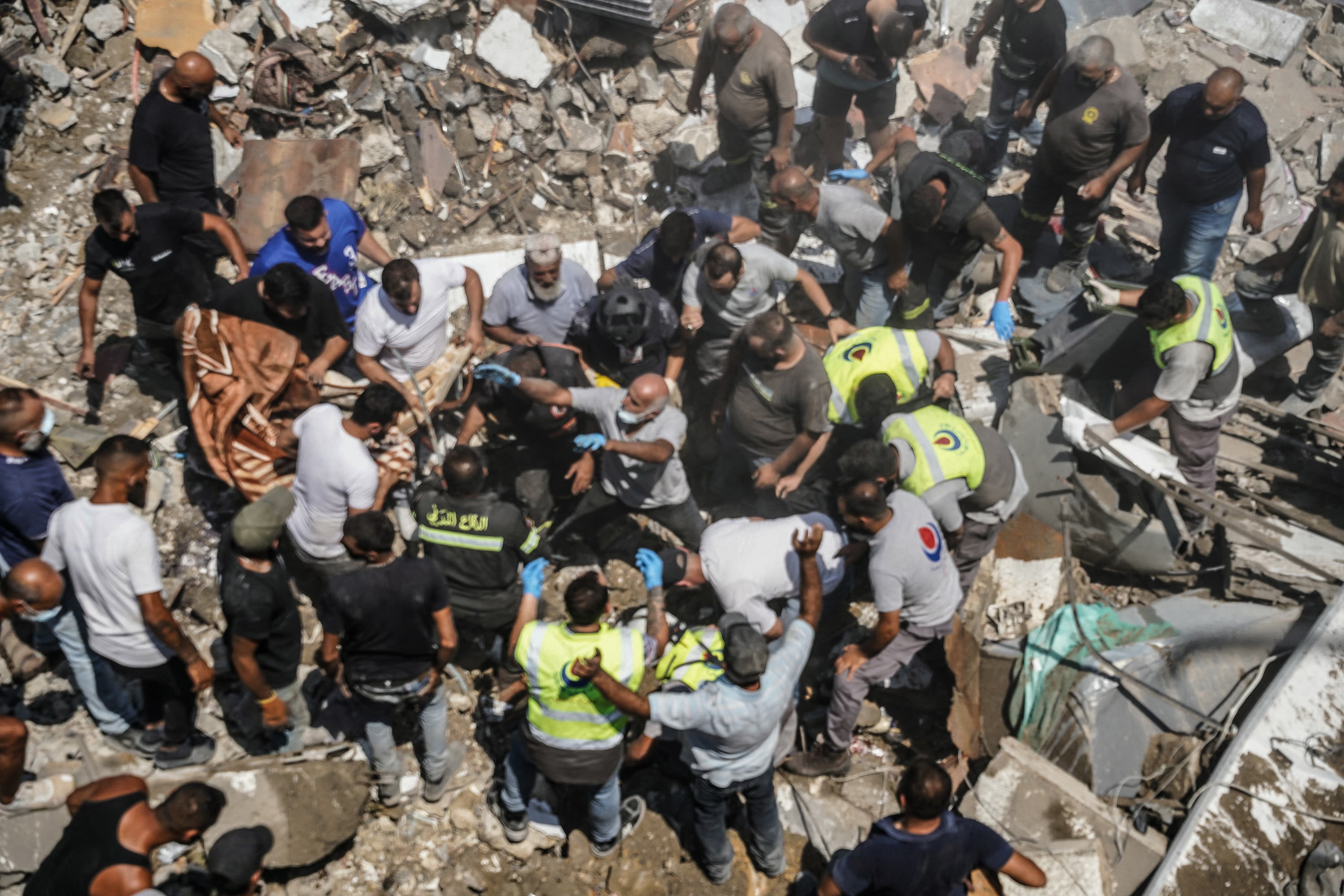 First aid responders and residents gather as they search the site of an Israeli airstrike that targeted a neighbourhood in the southern Lebanese village of Deir al-Zahrani