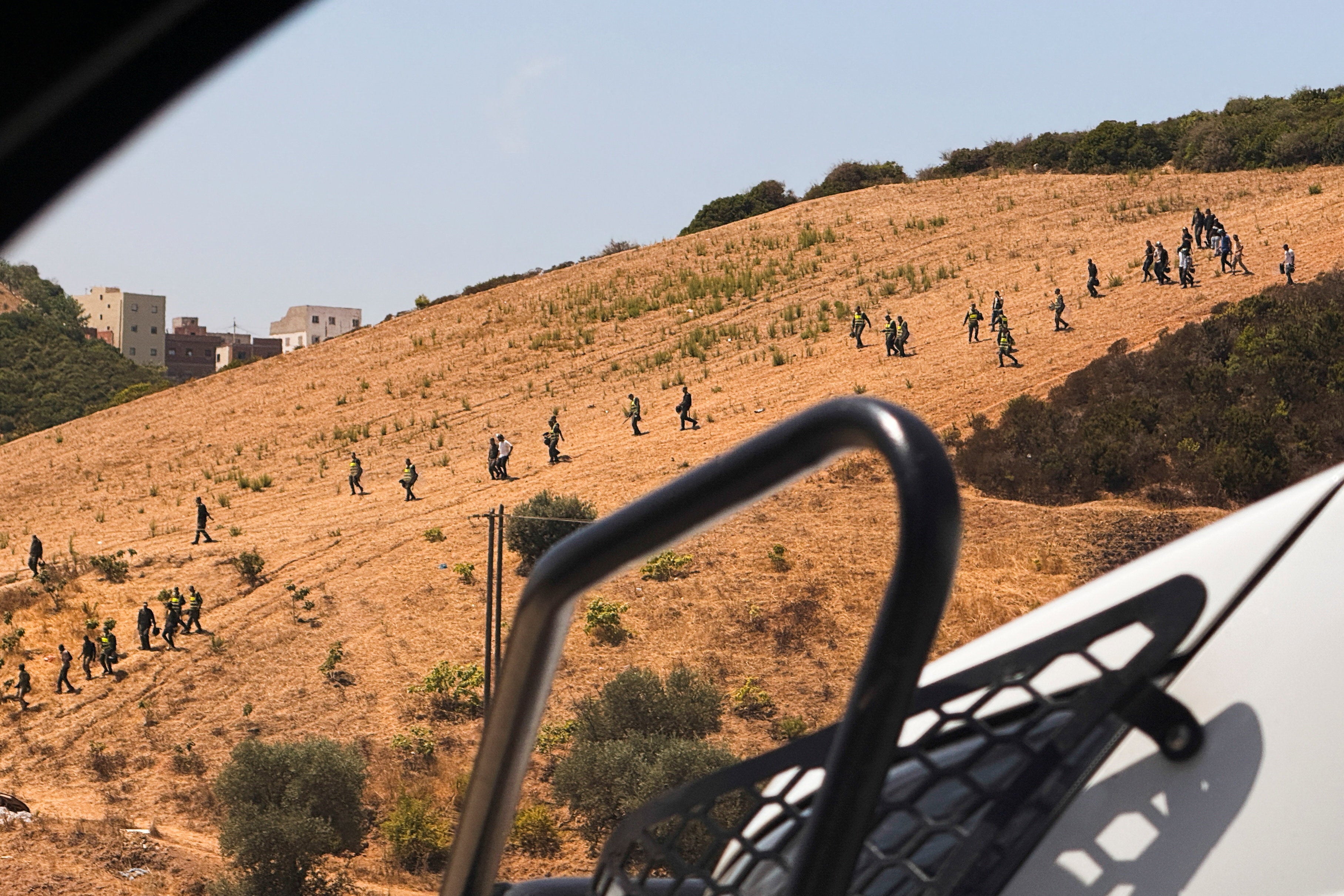 Moroccan security personnel search a hillside during an operation to locate migrants potentially attempting to cross irregularly into the Spanish enclave of Ceuta, in Fnideq, Morocco, August 15, 2026