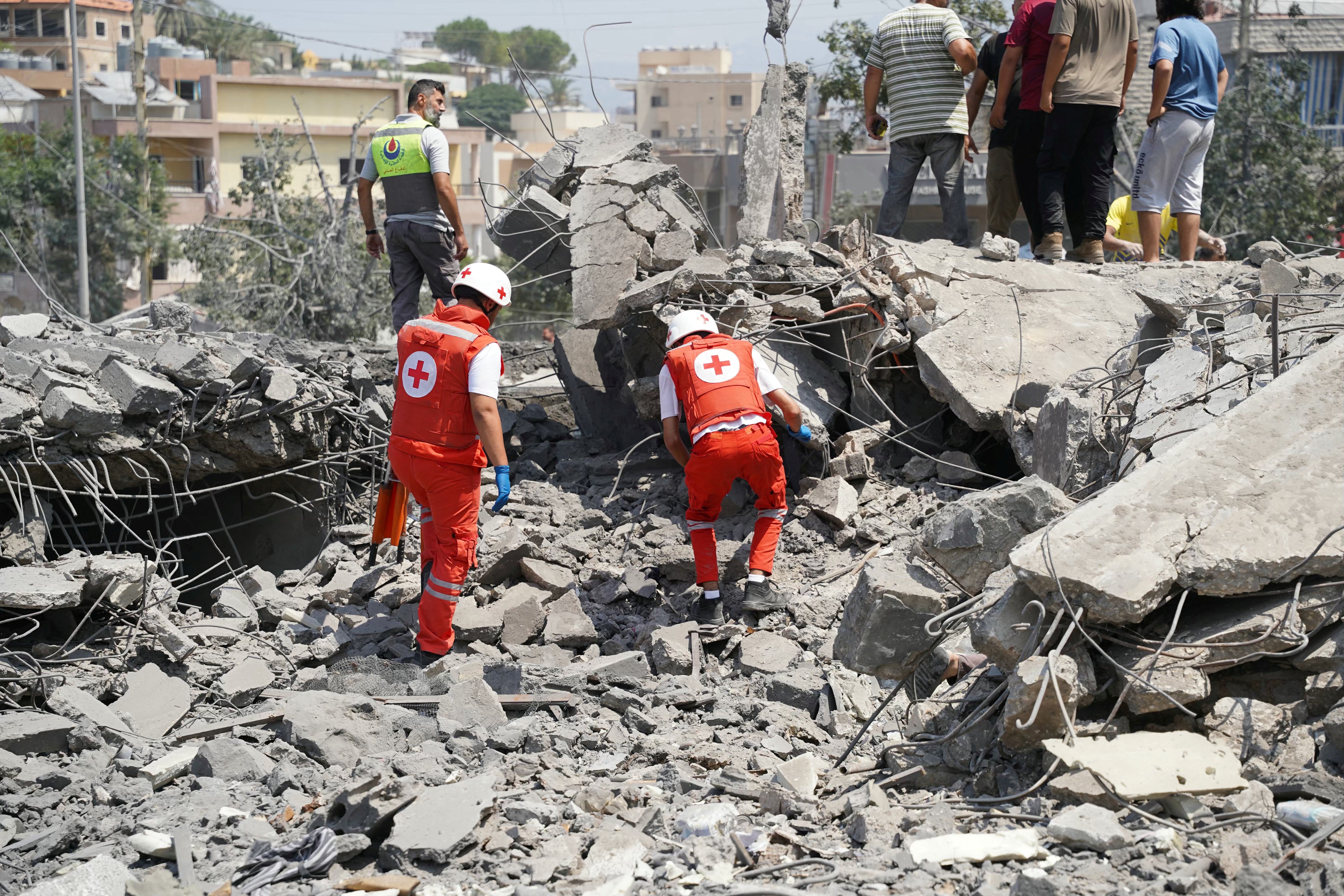 First aid responders and residents rush to the site of an Israeli airstrike in the southern Lebanese village of Deir al-Zahrani