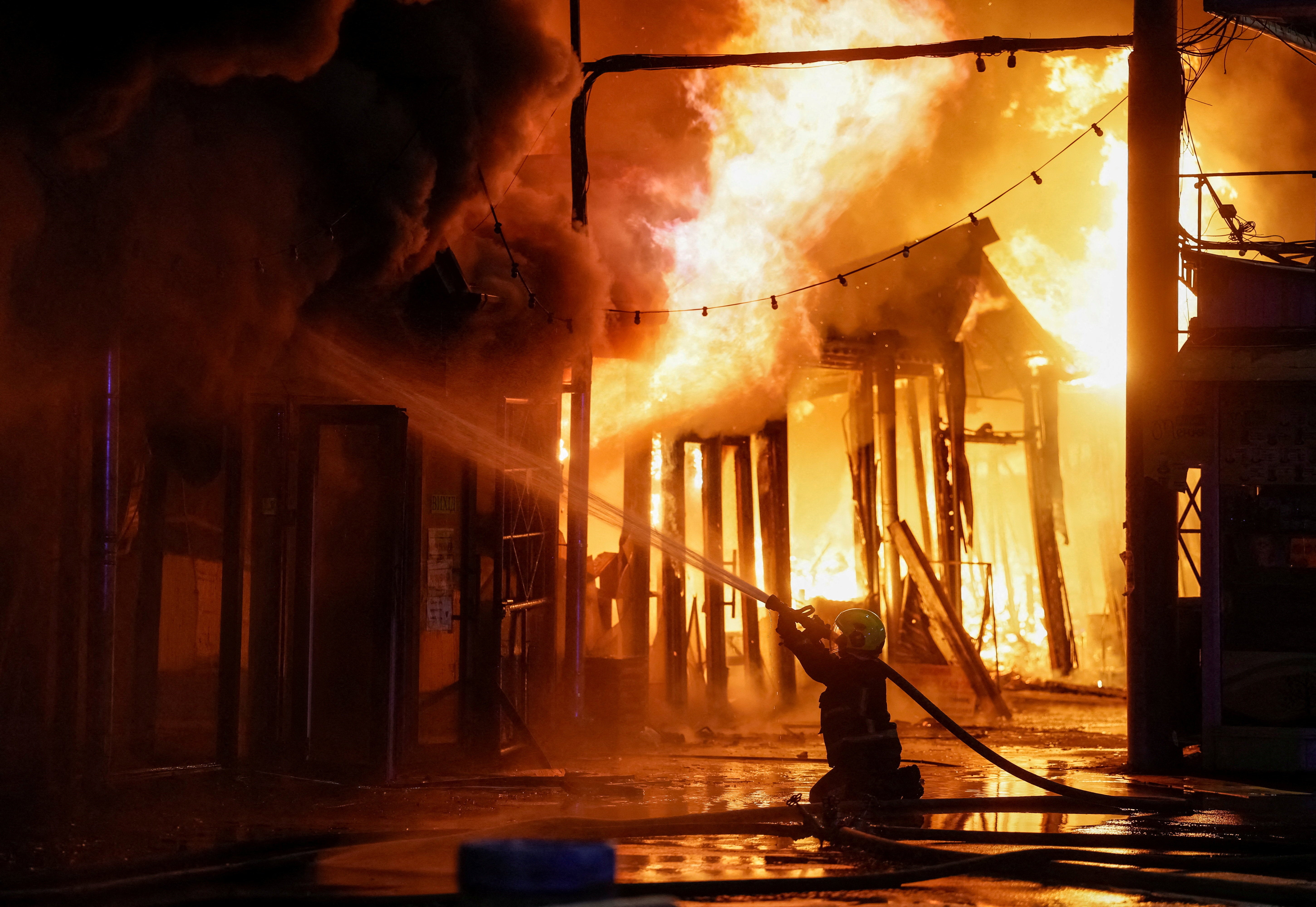 A firefighter works at a site of a book market hit by a Russian missile strike