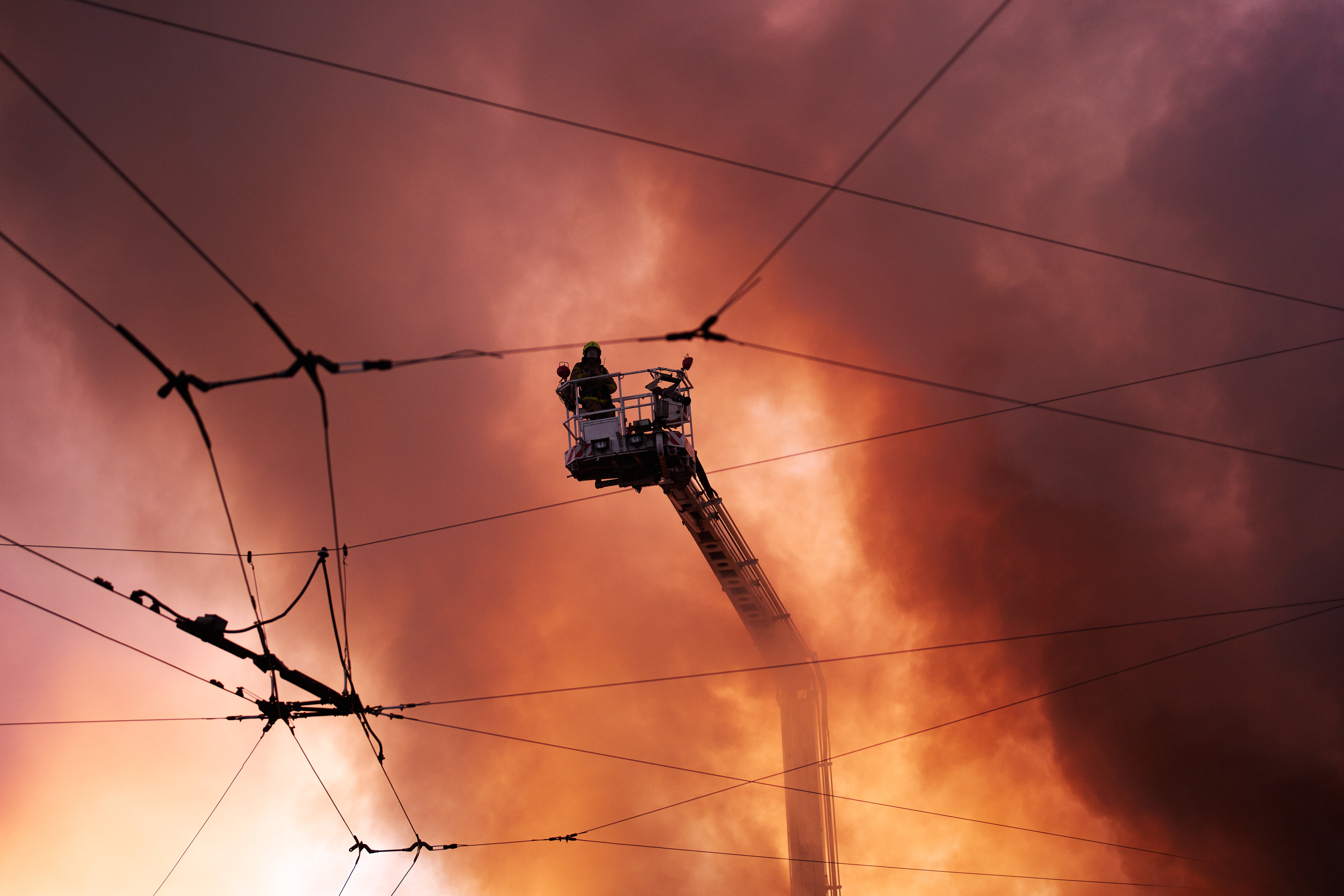 Firefighters try to put out a fire at a city book market following a Russian missile attack in Kyiv