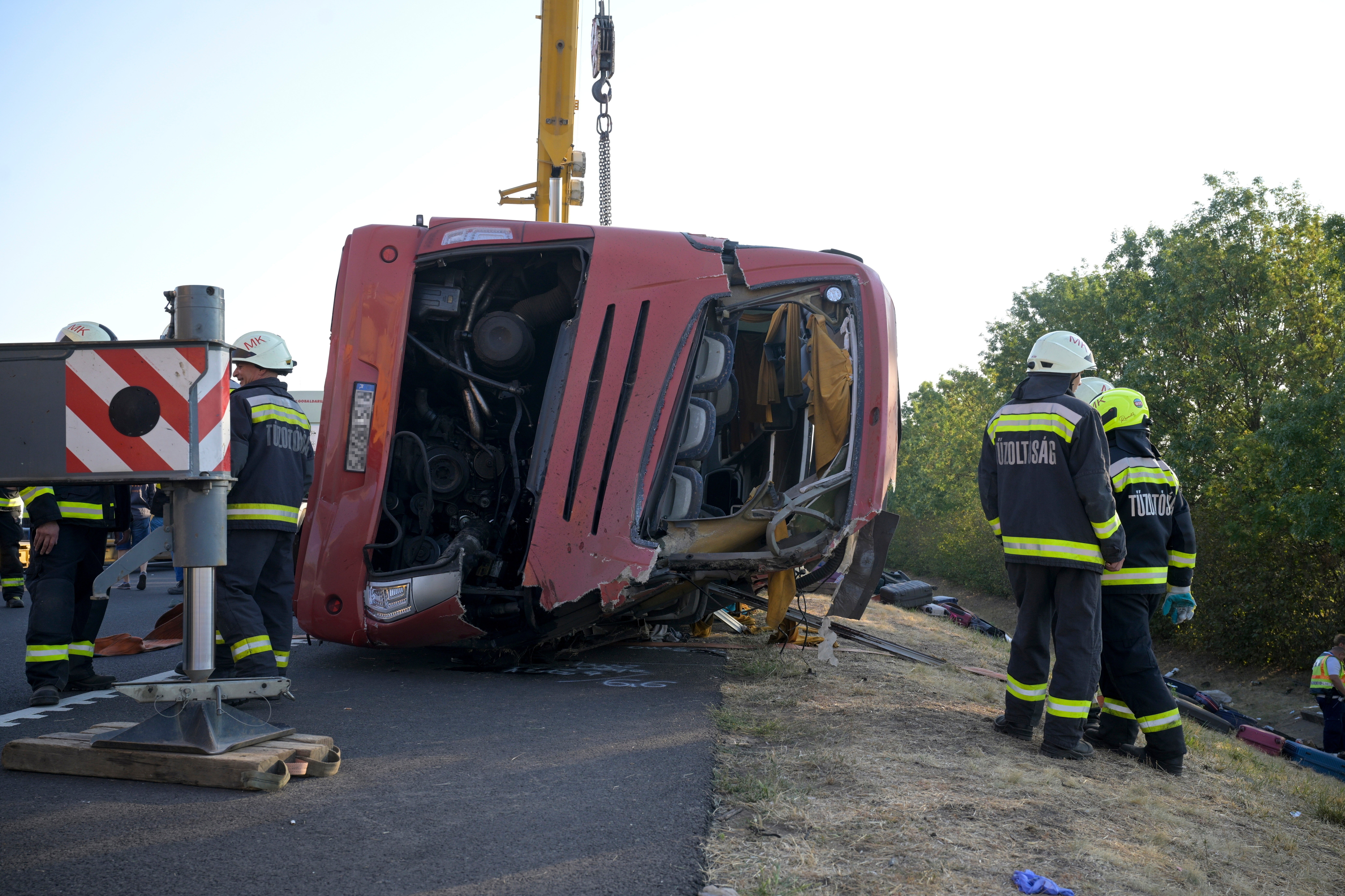 Emergency services attend the scene after a passenger bus went off the road and overturned in a ditch along a highway between Mezokeresztes and Mezonagymihaly in Hungary,