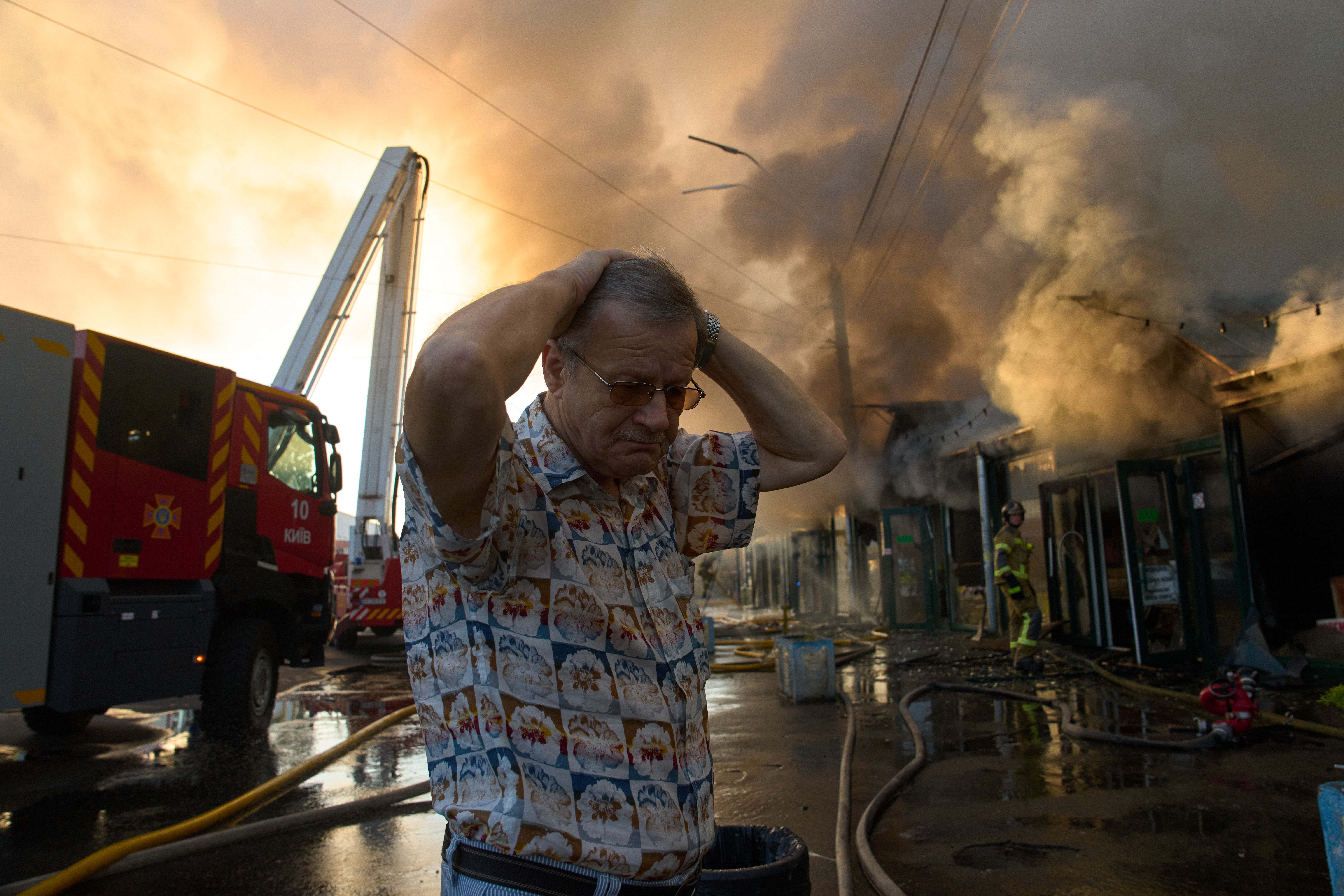Bookseller Alexander Bahlai reacts as firefighters try to put out a fire at a city book market
