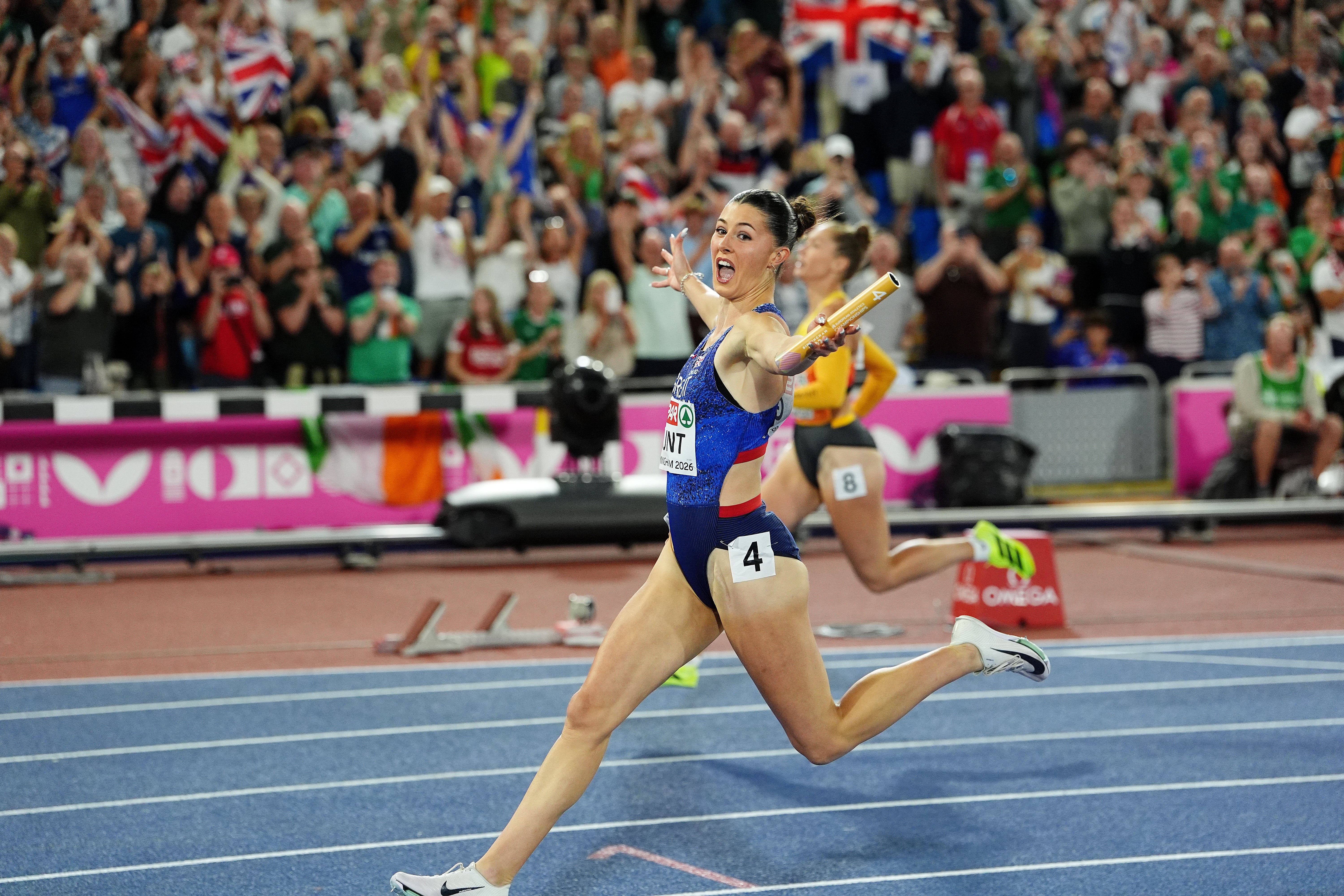 Hunt celebrates gold as she crosses the line after running the fourth leg in Birmingham