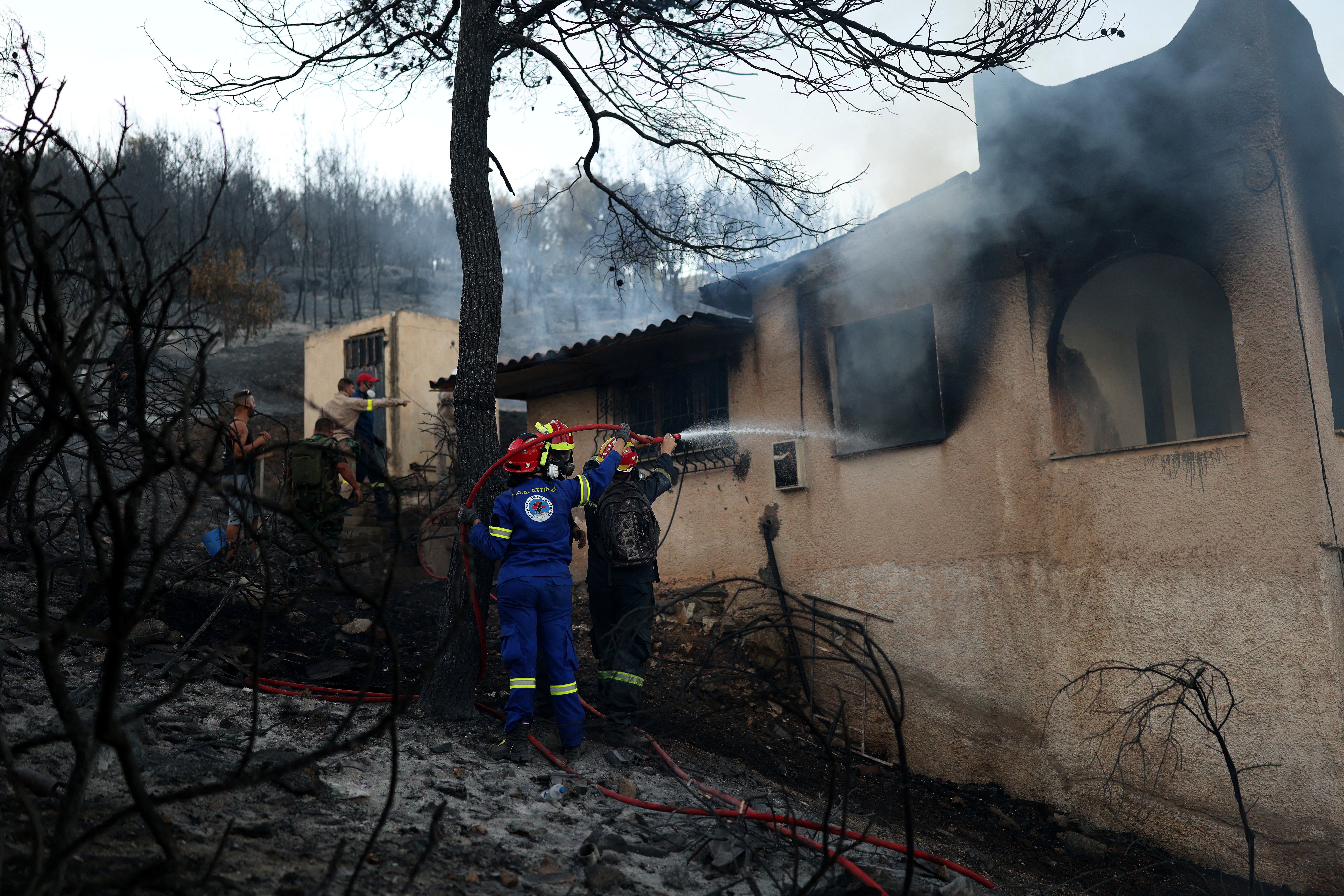 People battle a wildfire in Peristeria area, Salamina island, near Athens, Greece, August 16, 2026