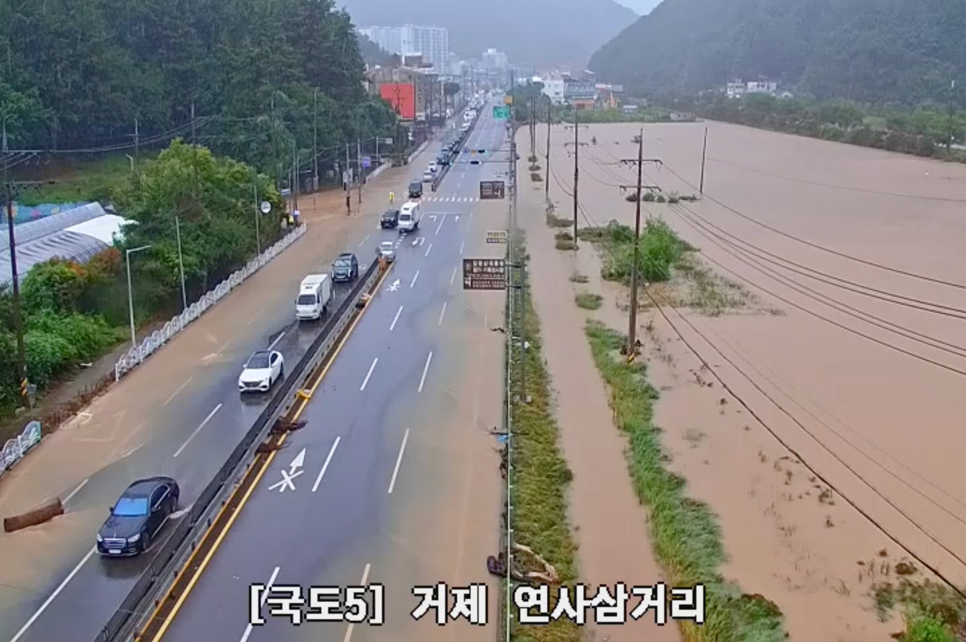 Vehicles navigate flooded road in South Korea's Geoje