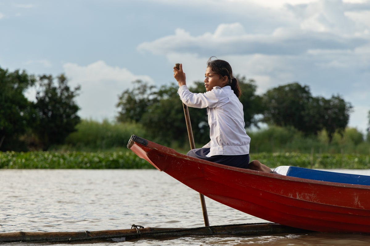 Children in Cambodia's Tonle Sap region navigate water to attend school