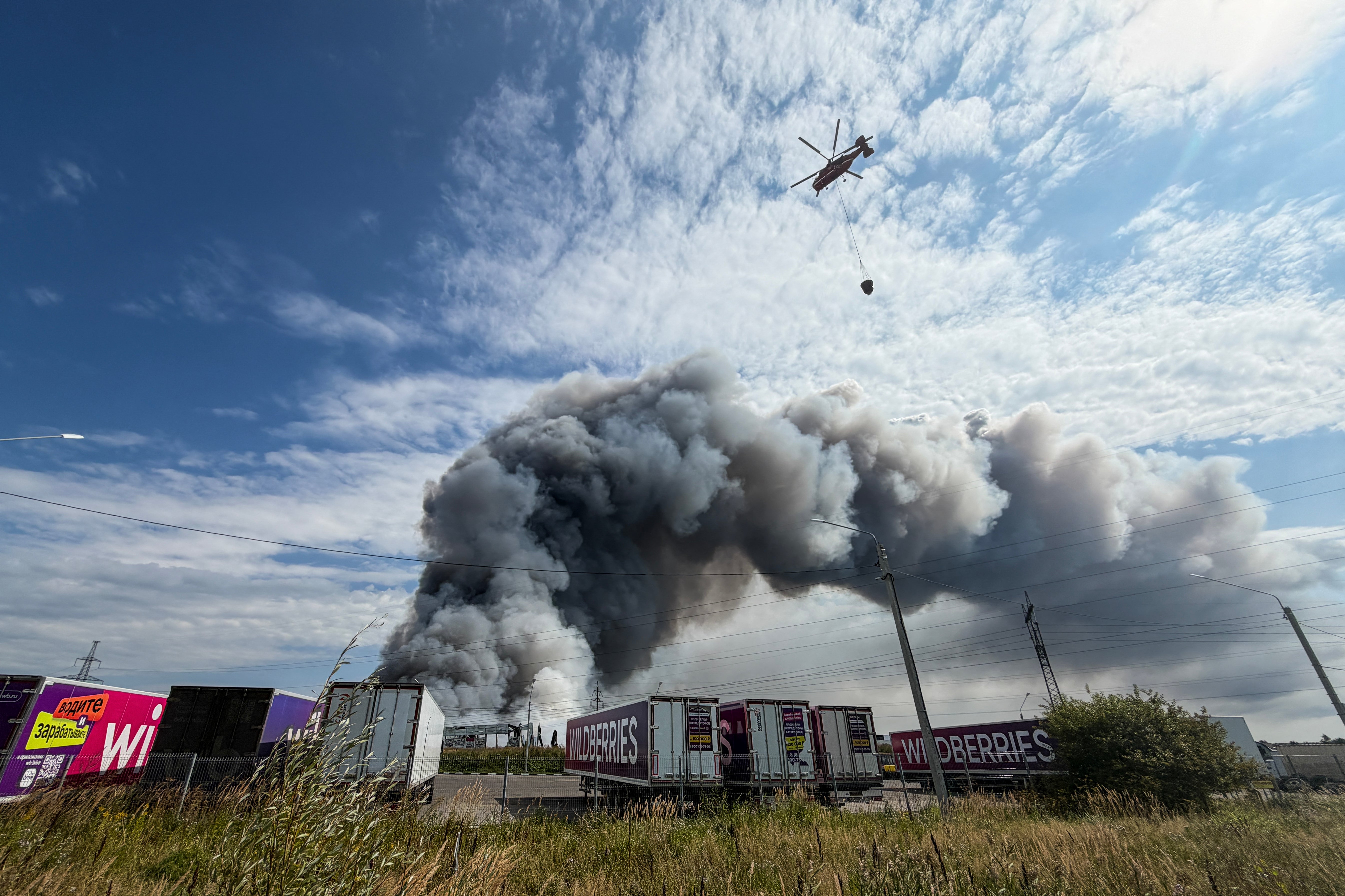 A firefighting helicopter prepares to drop a load of water during a fire at Russian e-commerce firm Wildberries' logistics complex near the town of Podolsk, outside Moscow