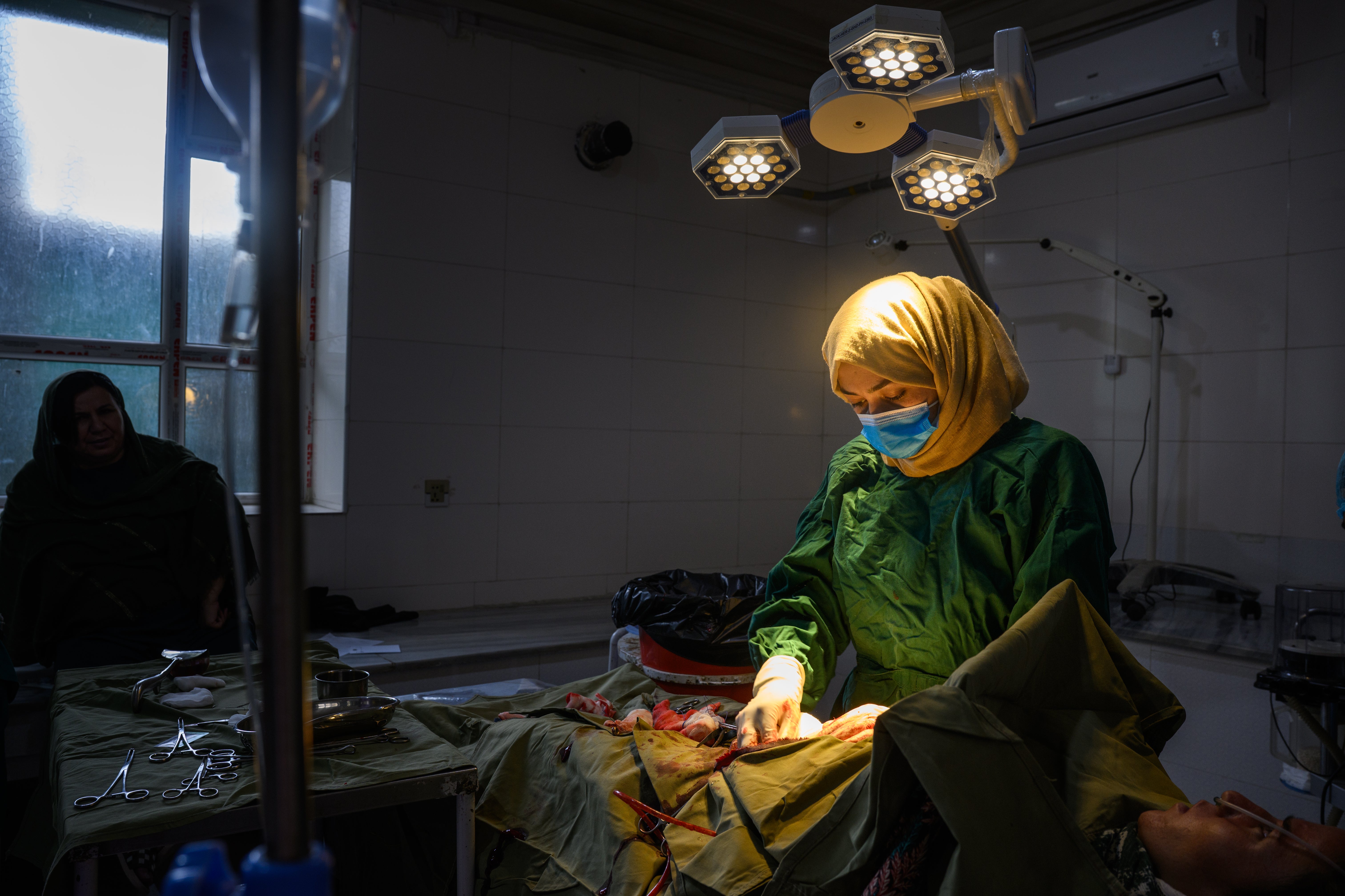 A medical doctor and surgeon completes a C-section after assisting another surgeon at the provincial hospital's maternity unit in Ghazni