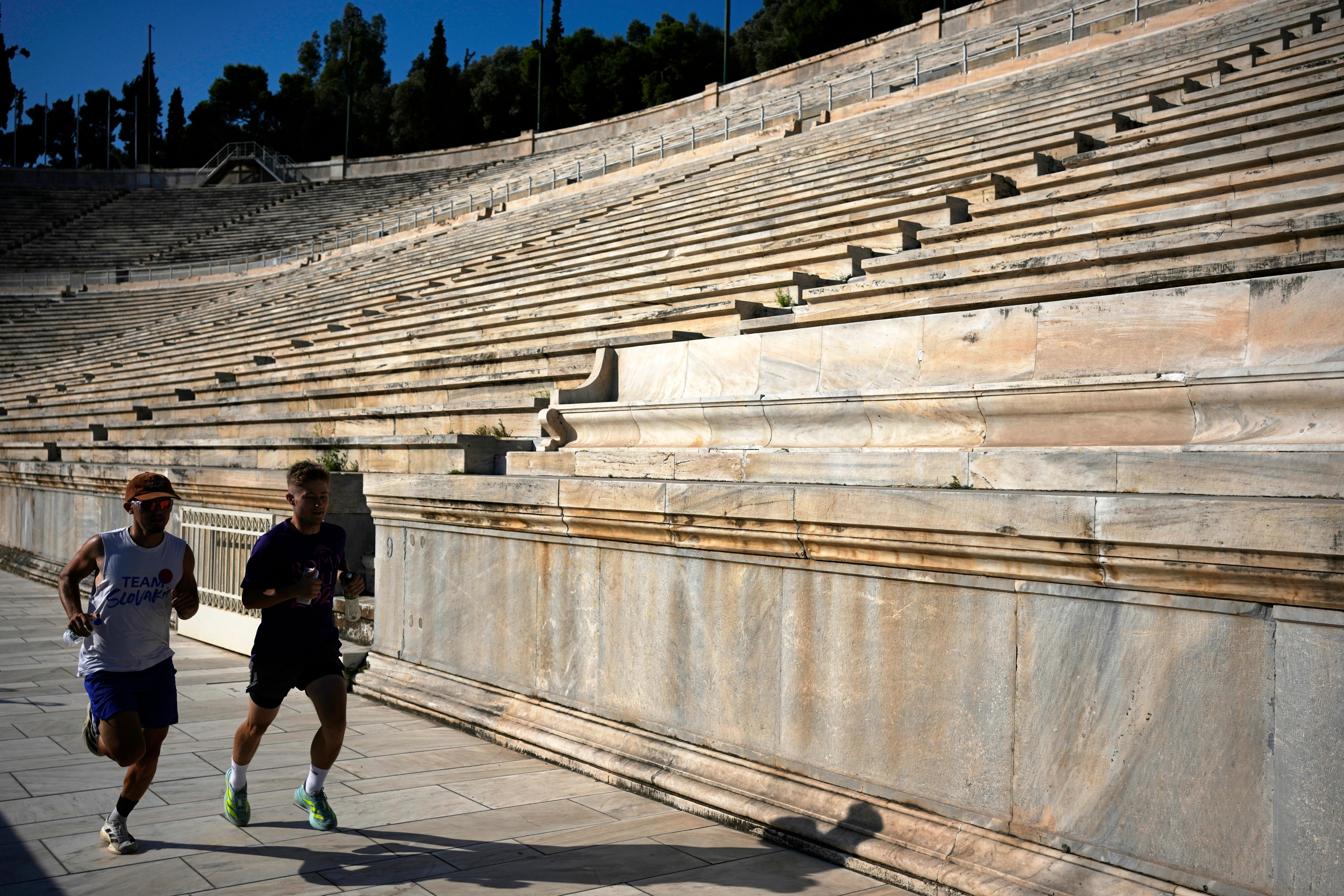 Two men run at the Panathenaic Stadium during the renovation works