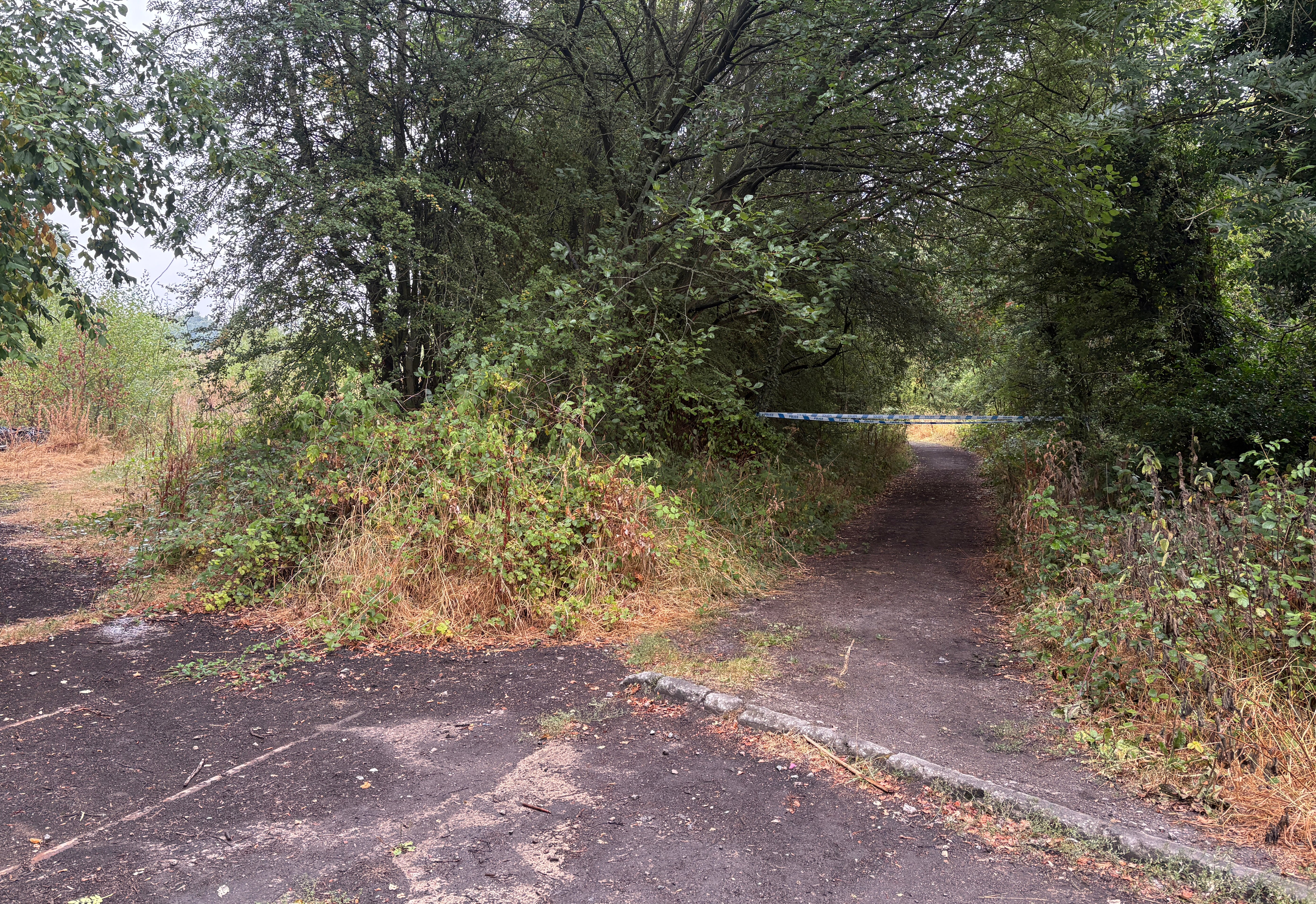 Police tape blocks the entrance at the old train line footpath off Blacker Lane