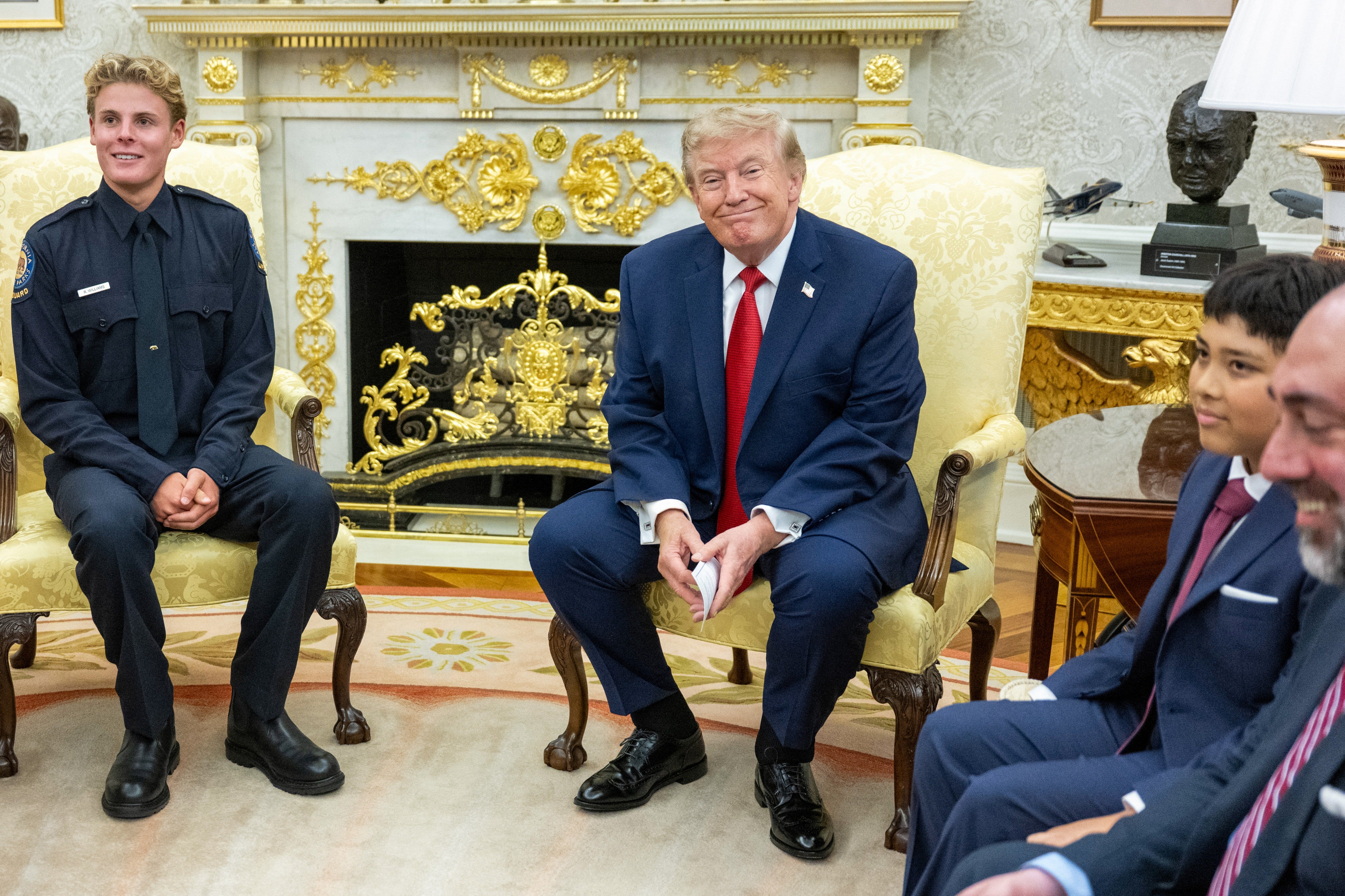 Trump held the card during his meeting with Ryder Williams, a 16-year-old California lifeguard, and Nathaniel Rai, 10, whom Williams rescued from drowning at a Santa Cruz beach in July