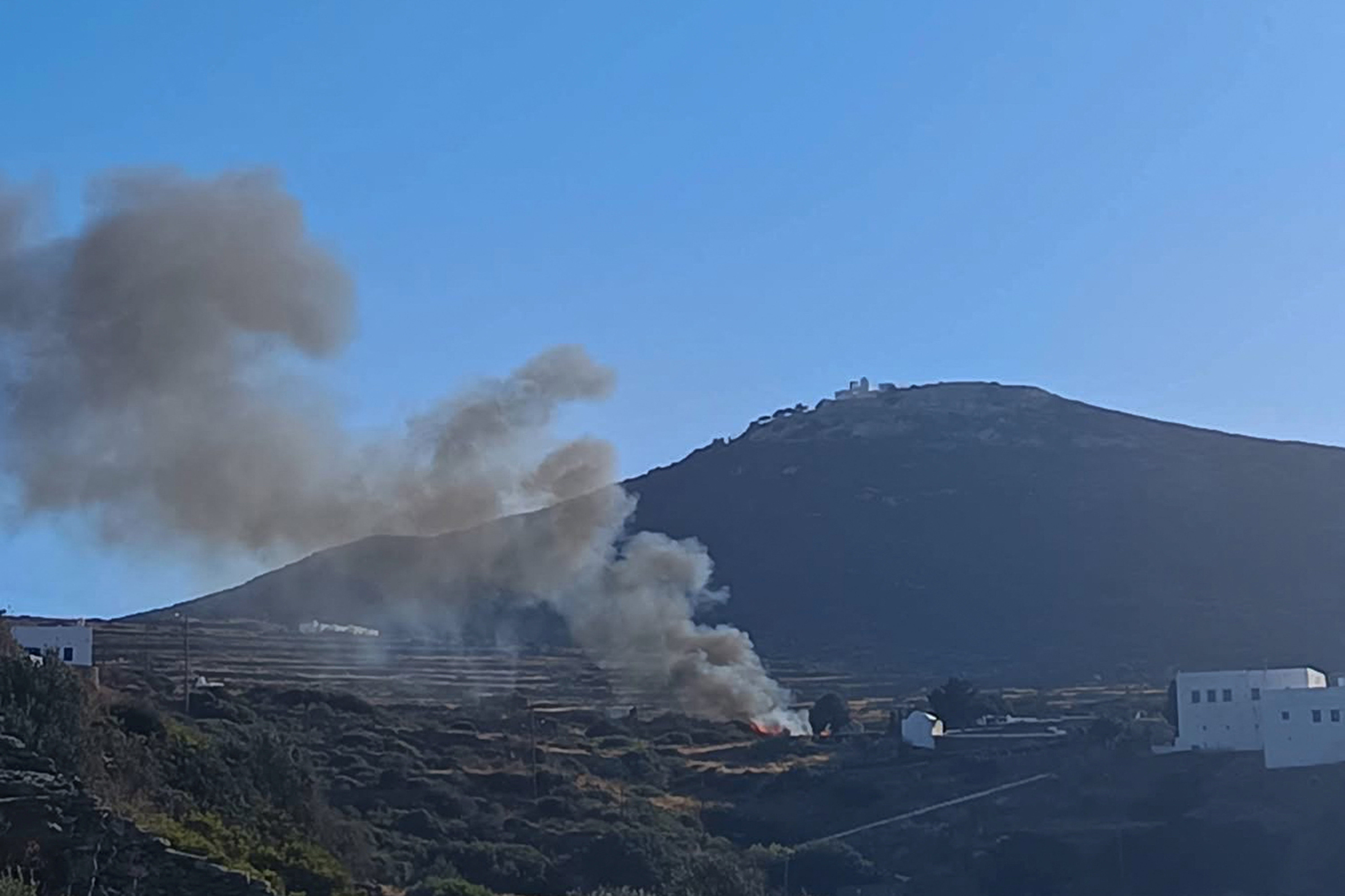 Smoke billows from the site of a helicopter crash on the island of Sifnos
