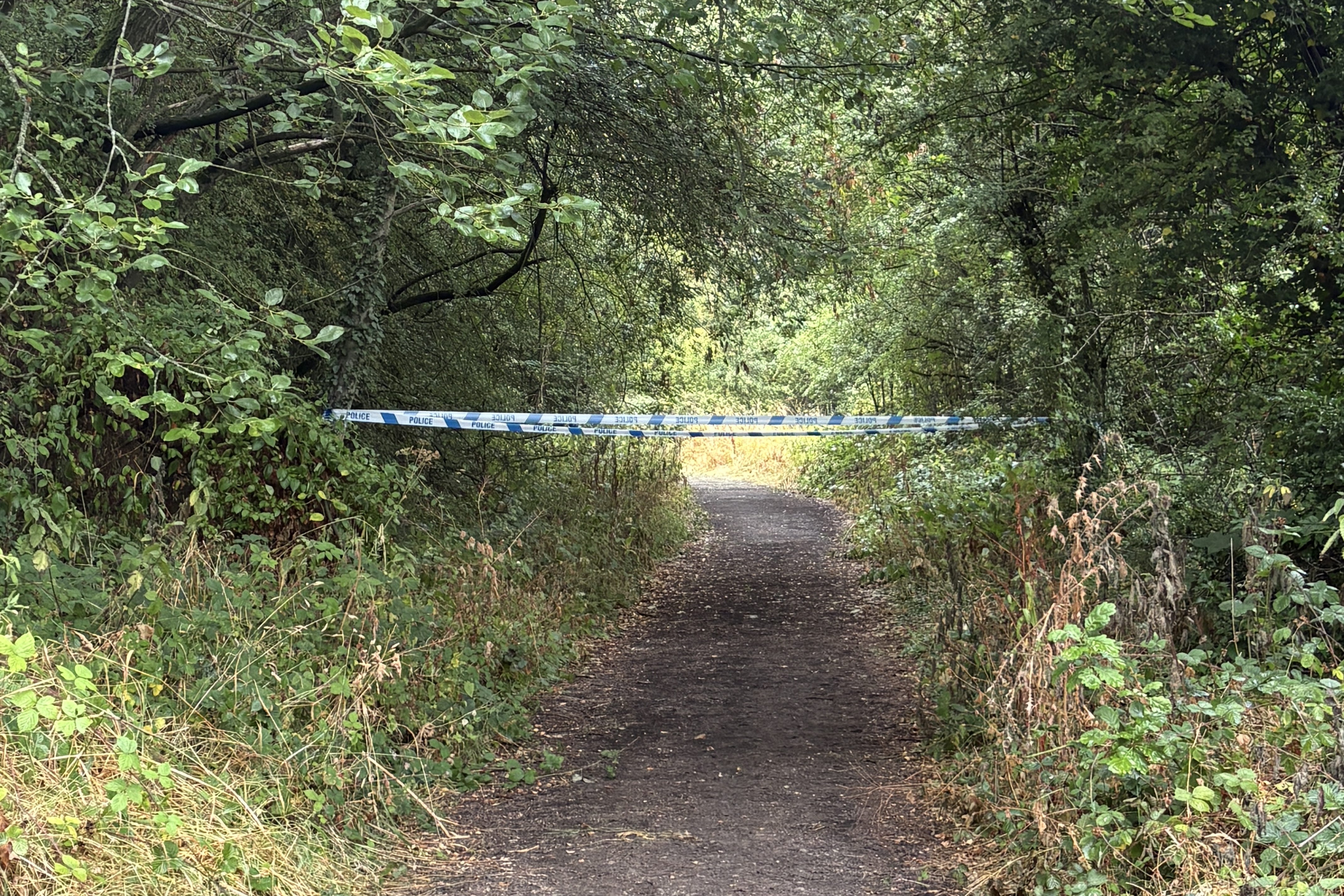 Police tape blocks the entrance at the old train line footpath off Blacker Lane