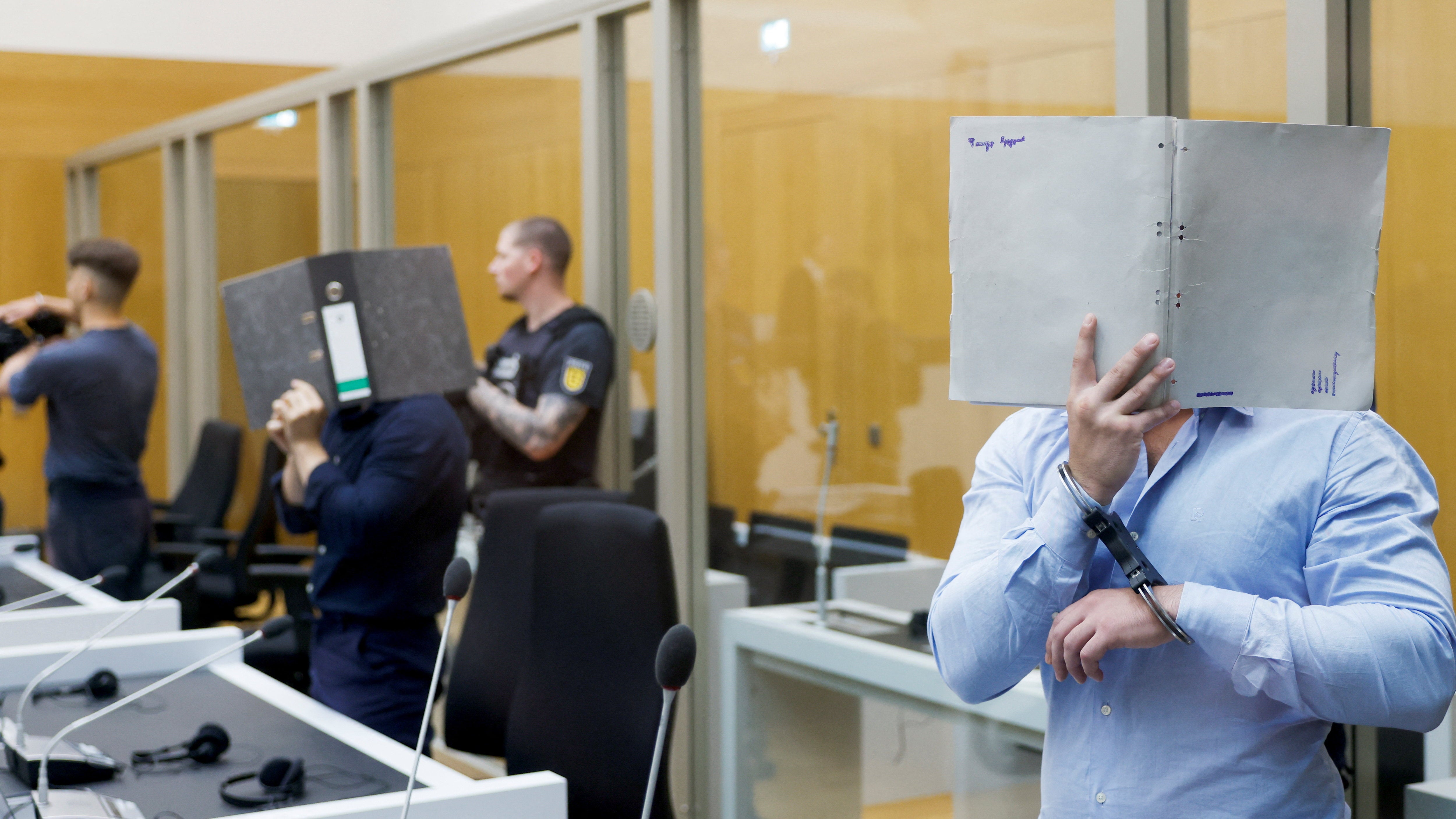 The Ukrainian defendants suspected to be acting on behalf of a Russian intelligence service covered their faces as they arrived in the courtroom