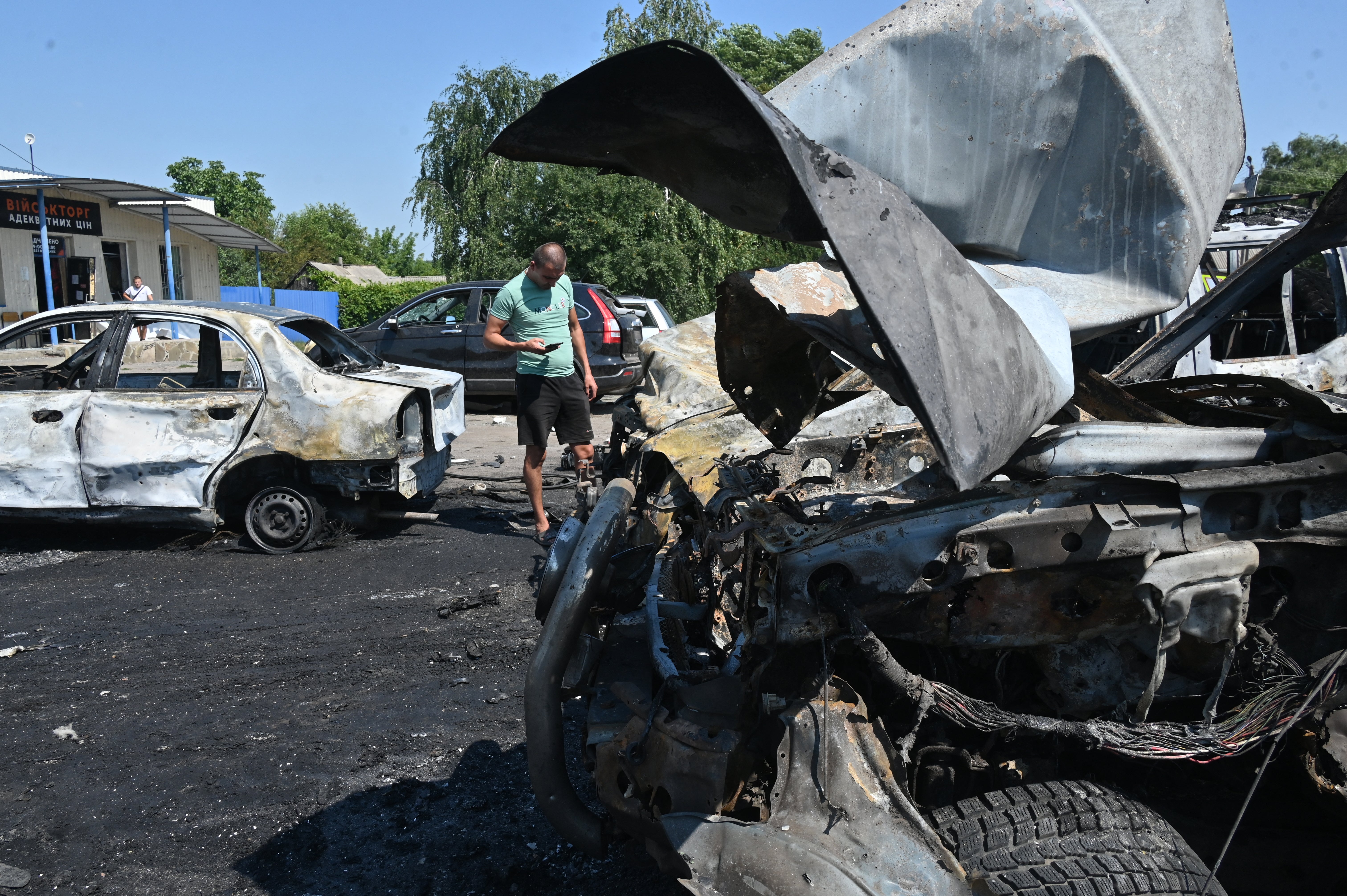 A man inspects burnt-out cars at the site of an air attack in Kharkiv