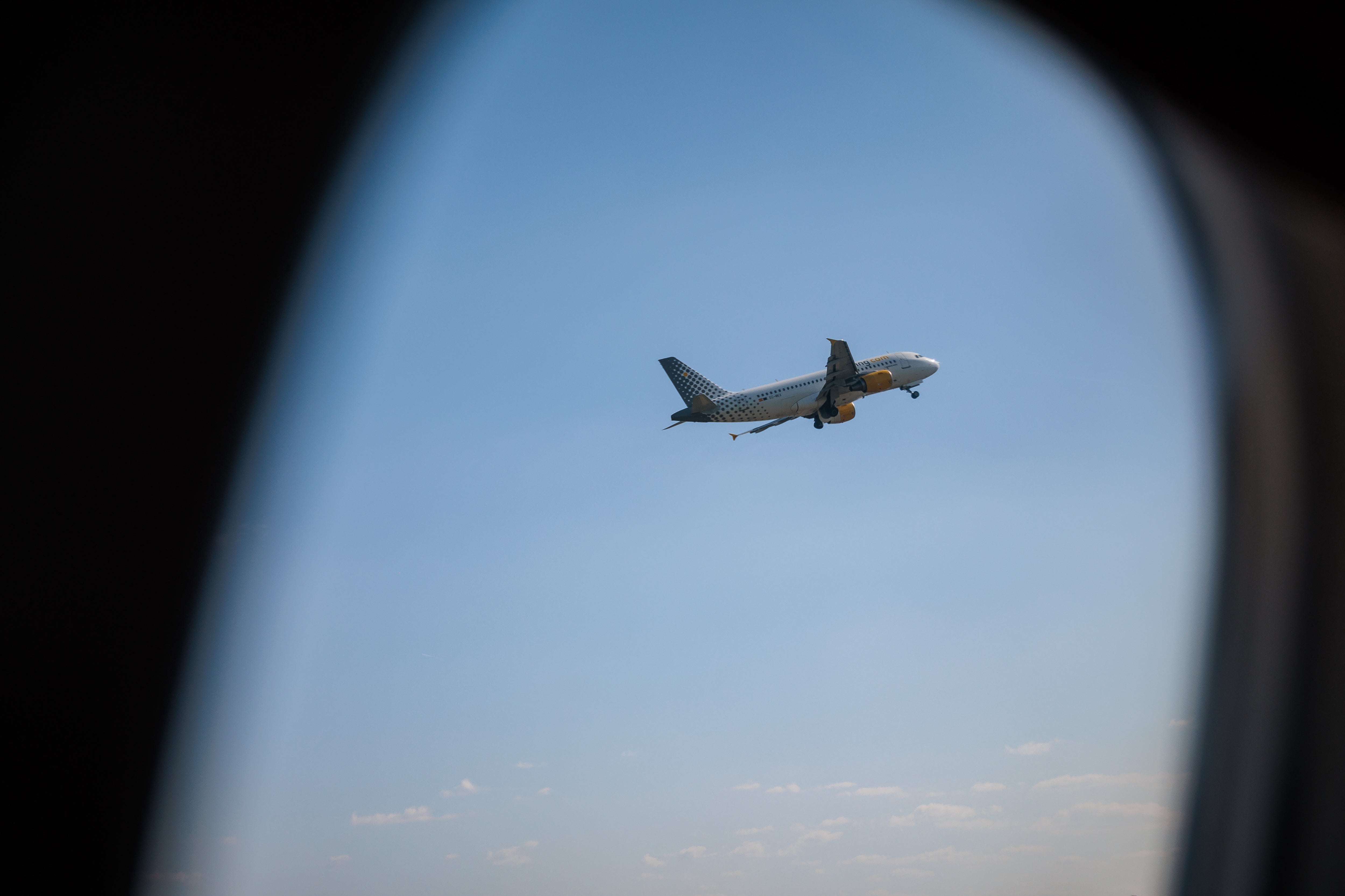 An airliner climbs after takeoff as seen through an aircraft window at Florence Airport in Florence