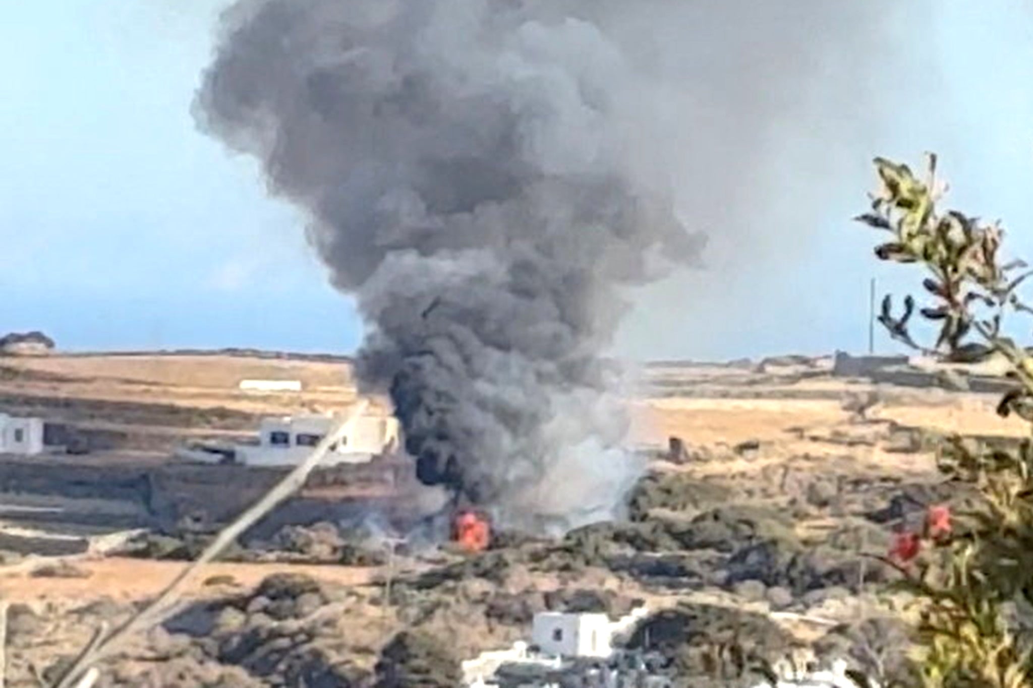 Smoke rises following a helicopter crash on the Greek island of Sifnos, 17 August