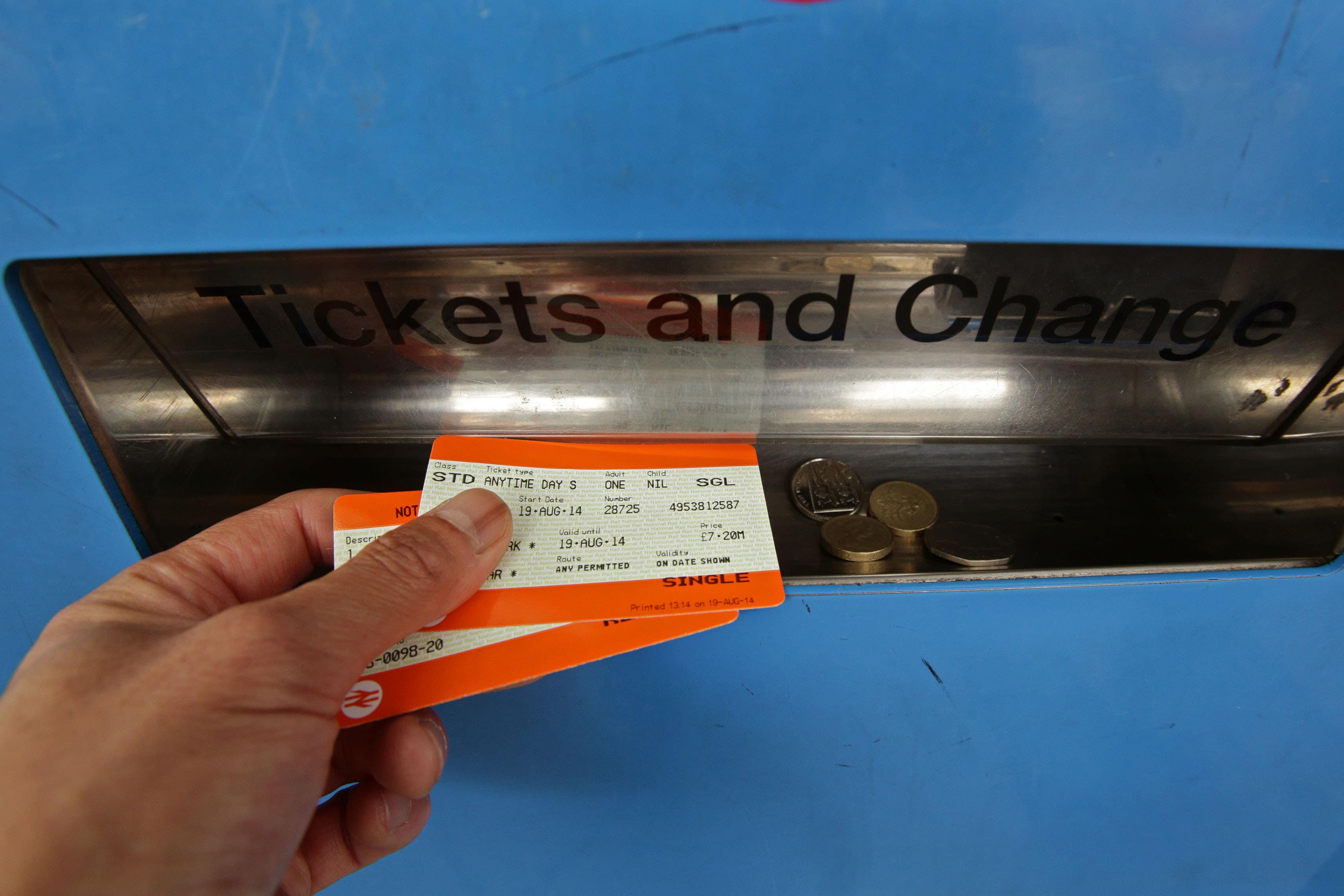 A passenger collecting train tickets from a machine at Finsbury Park station in north London