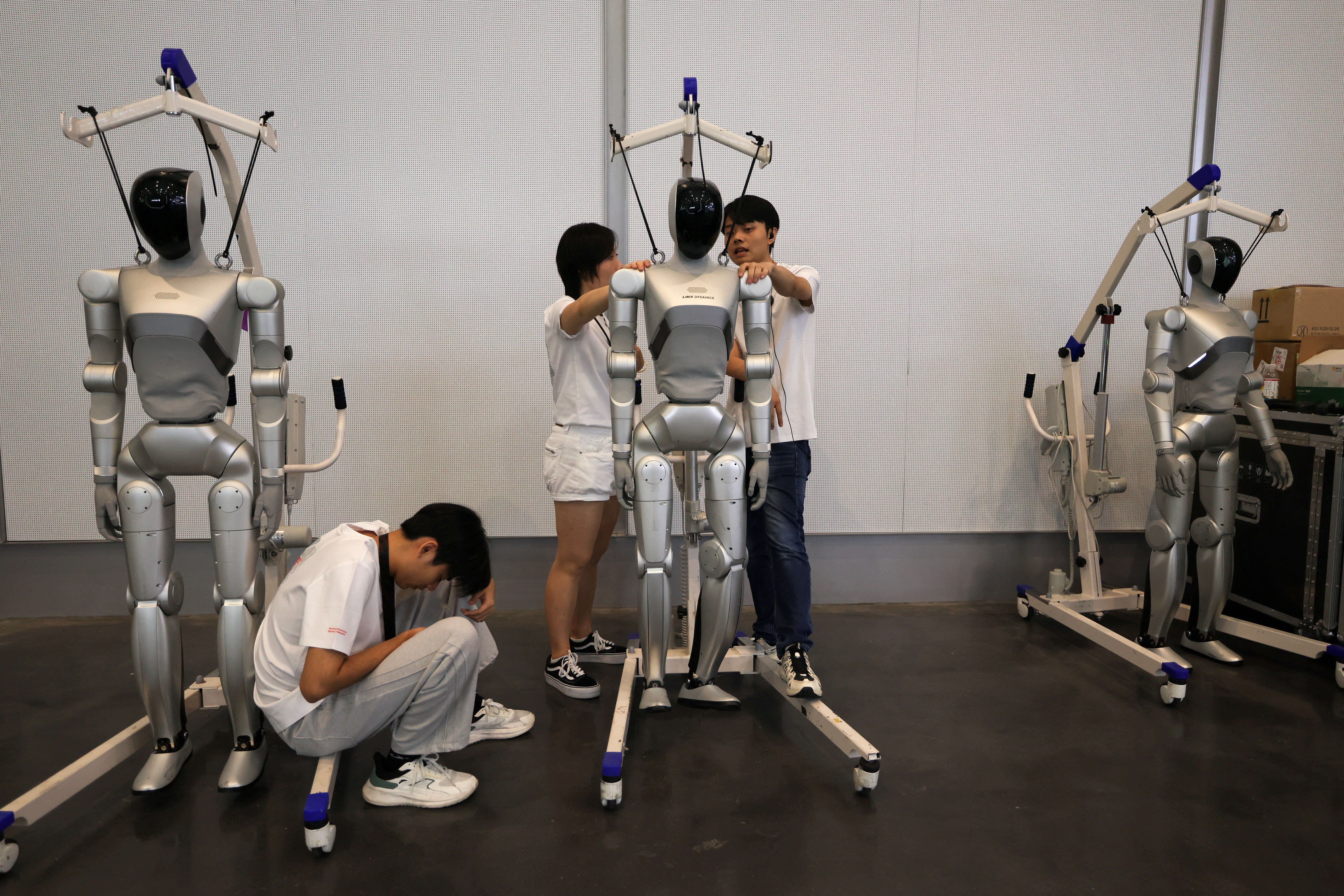 Staff members stand near humanoid robots by LimX Dynamics during the 2026 World Robot Conference, in Beijing, China August 19, 2026. REUTERS/Tingshu Wang (Reuters)