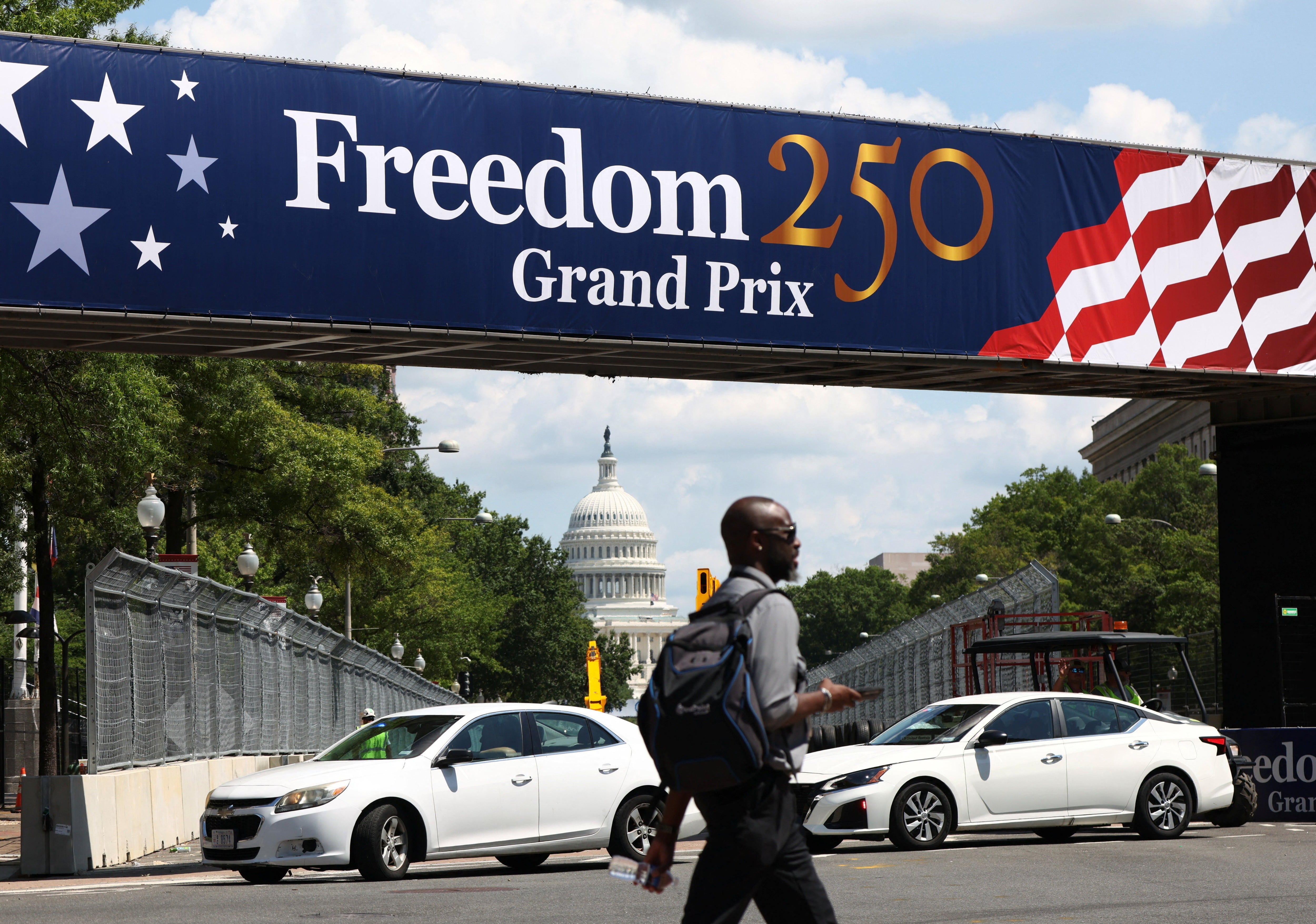 A man crosses a section of race track near the U.S. Capitol as preparations continue for weekend’s Freedom 250 Grand Prix IndyCar series race