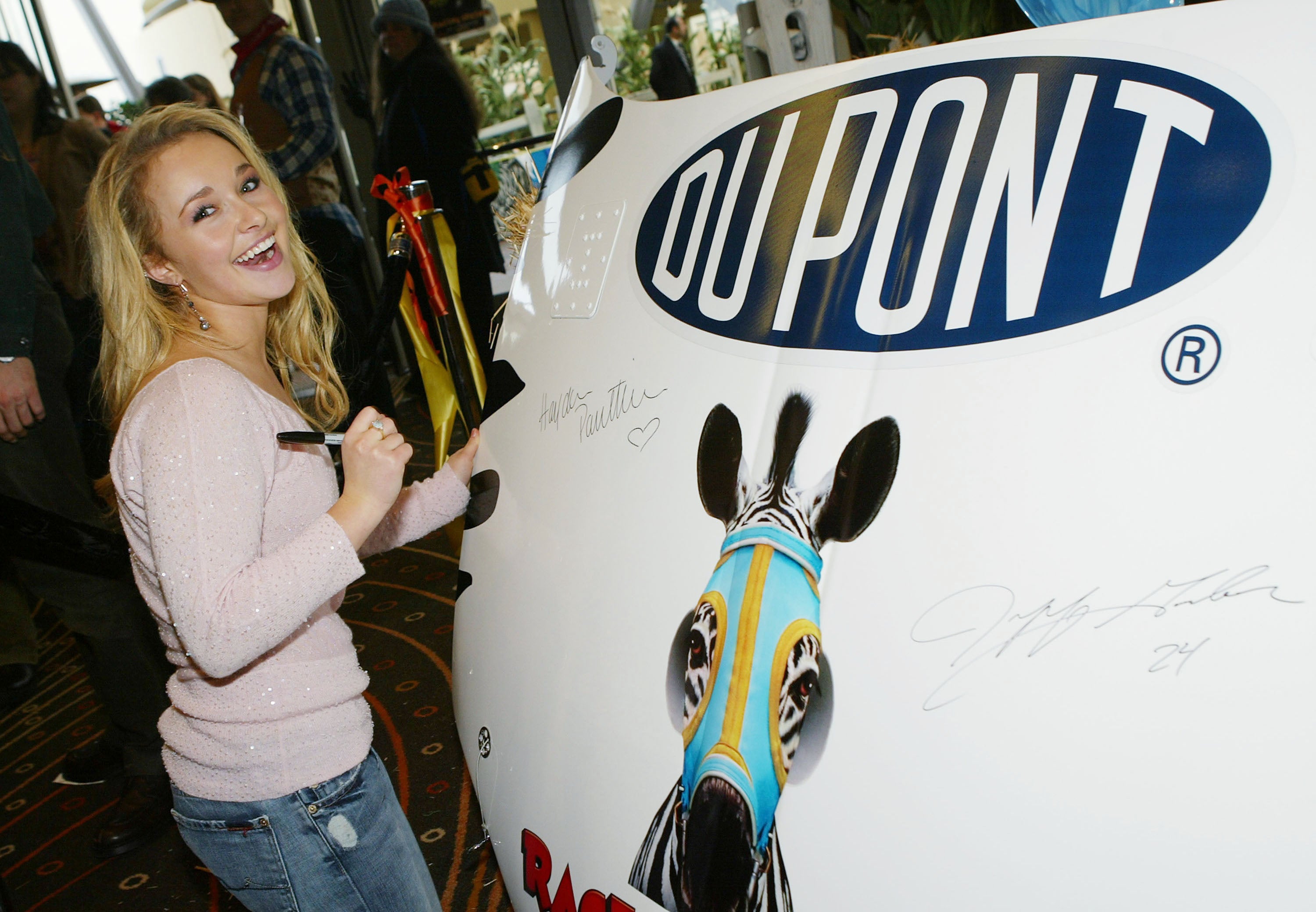 Hayden Panettiere signs a racing car hood to be auctioned for charity at the after party for the premiere of Warner Bros' 'Racing Stripes' in 2005 (Getty)