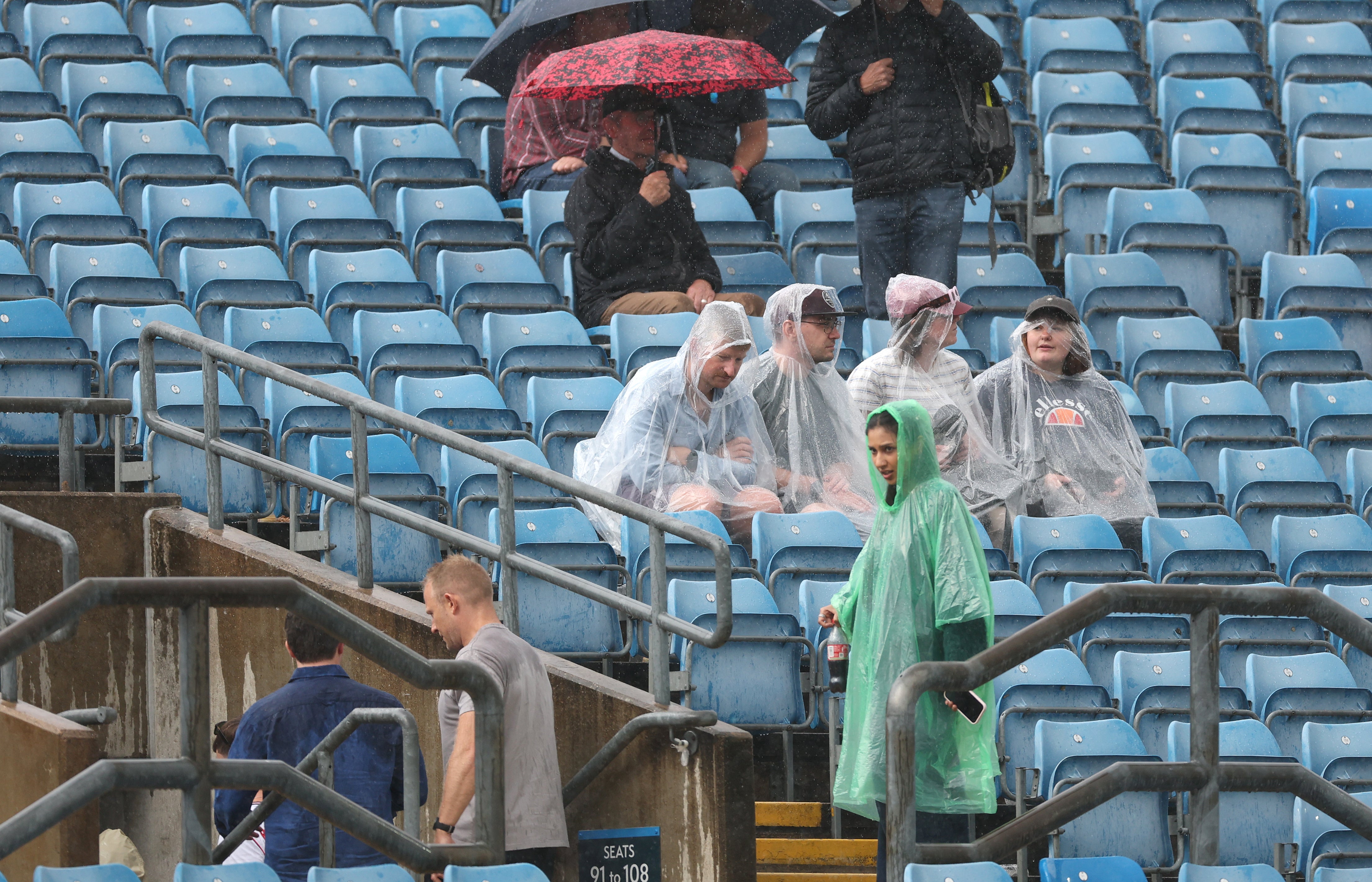 Spectators look on as rain stops play during day one of the 1st Rothesay Test Match between England and Pakistan at Headingley