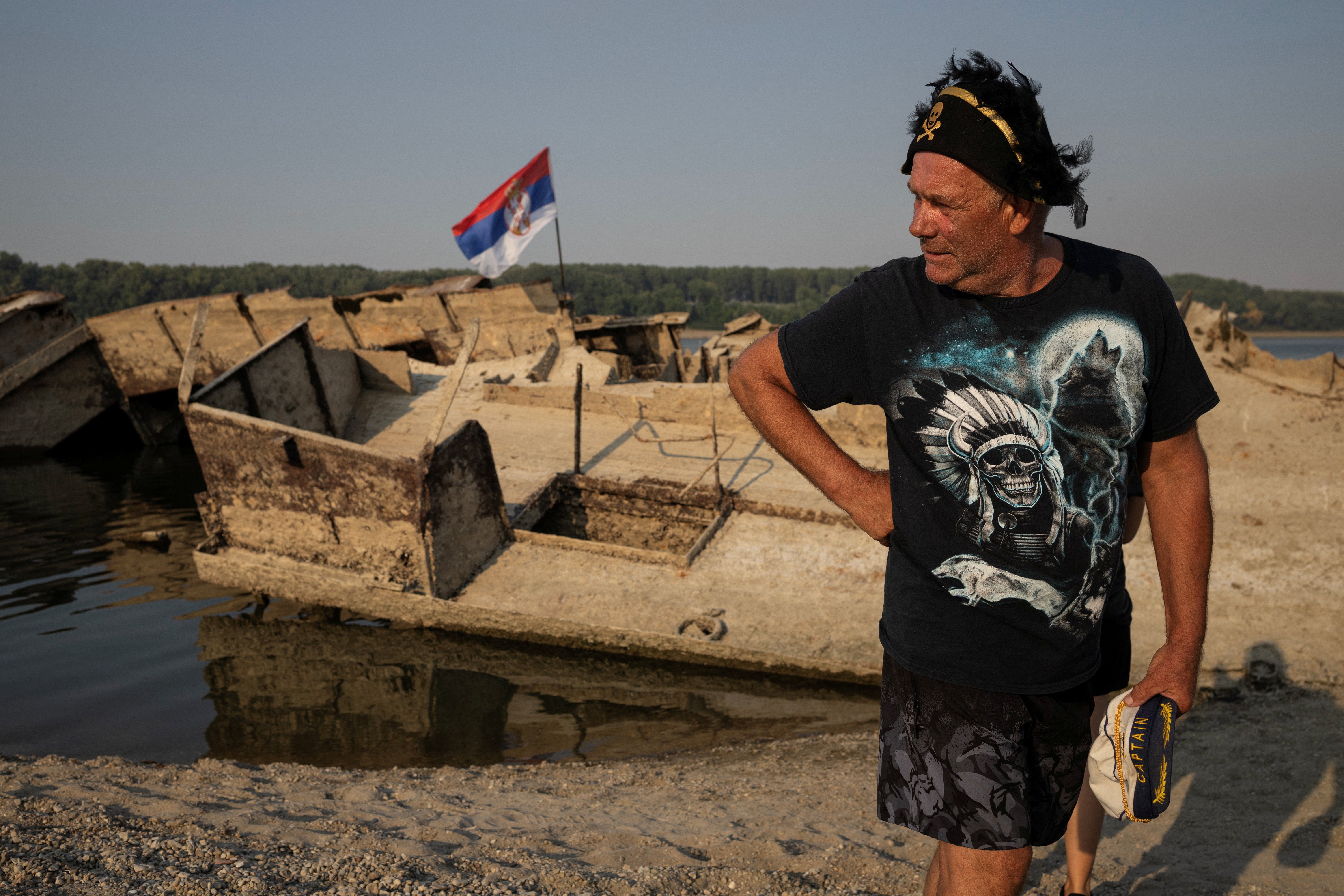 Zoran Lovric, a local fisherman, stands near a sunken German warship from the Second World War, exposed due to low Danube River levels near Prahovo, Serbia