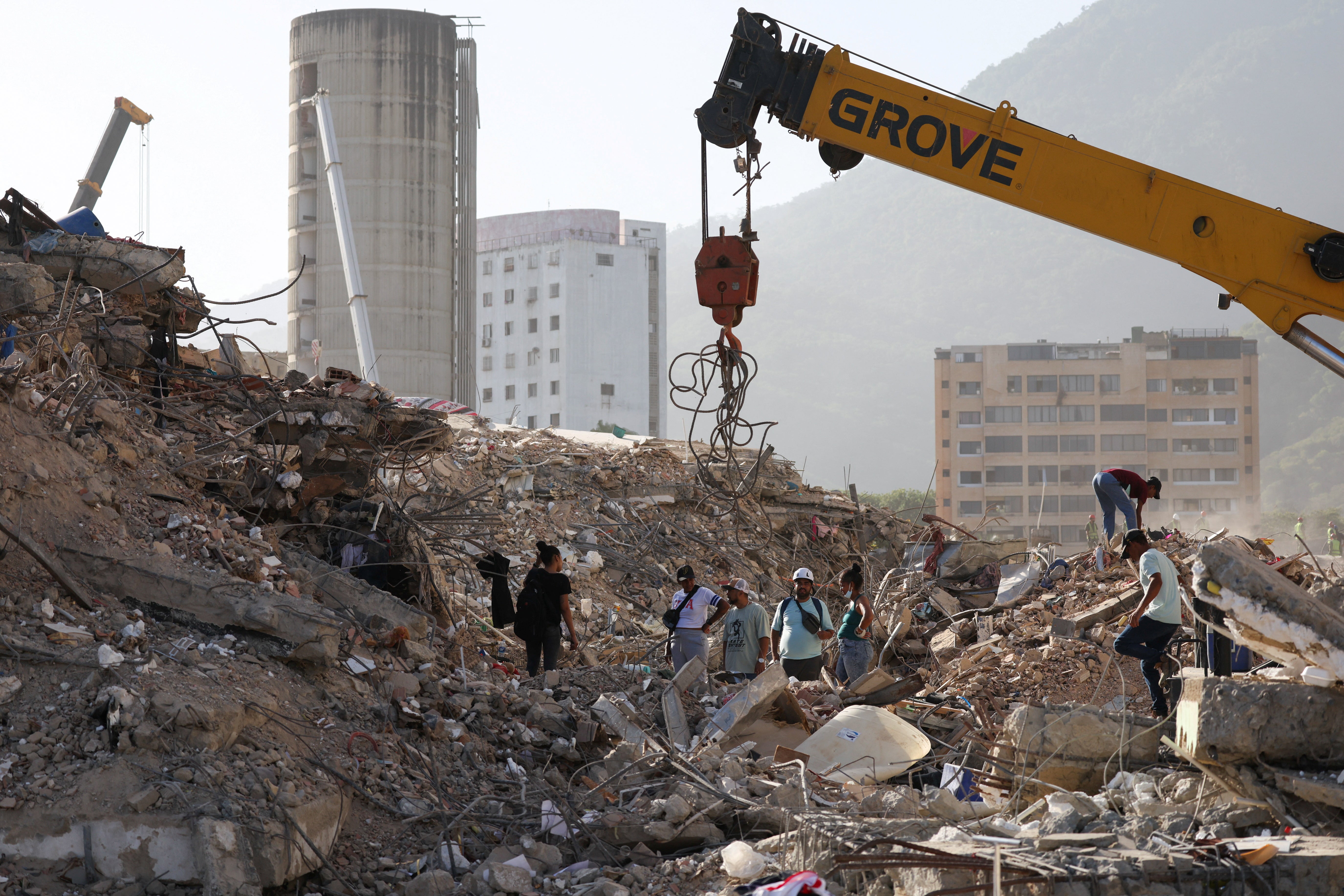 People work to remove debris from a collapsed building, as Venezuelans face worsening power and water shortages following government warnings of drought linked to the El Nino phenomenon