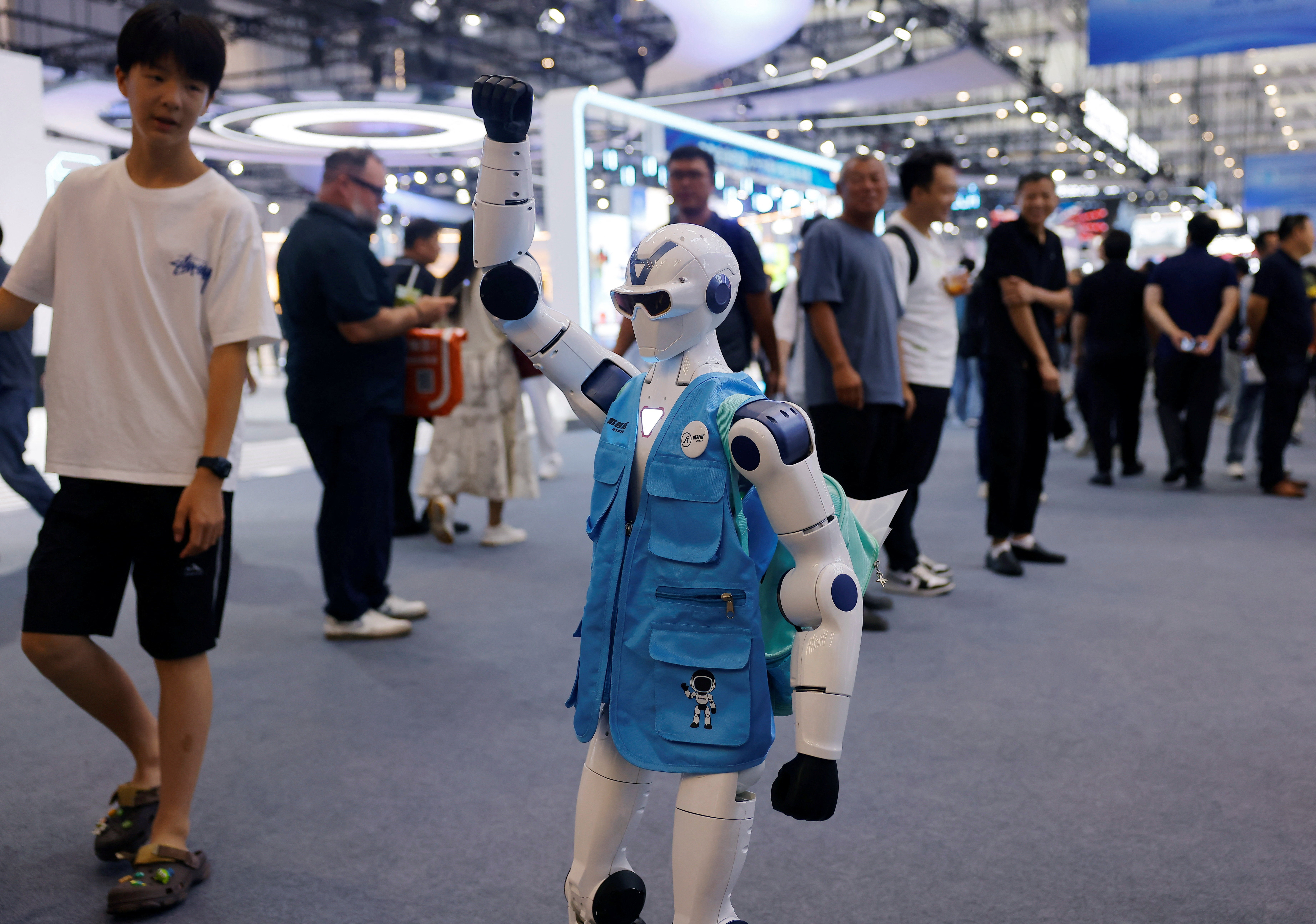 People look at a Unitree R1 robot wearing a branded vest at the 2026 World Robot Conference (Reuters)