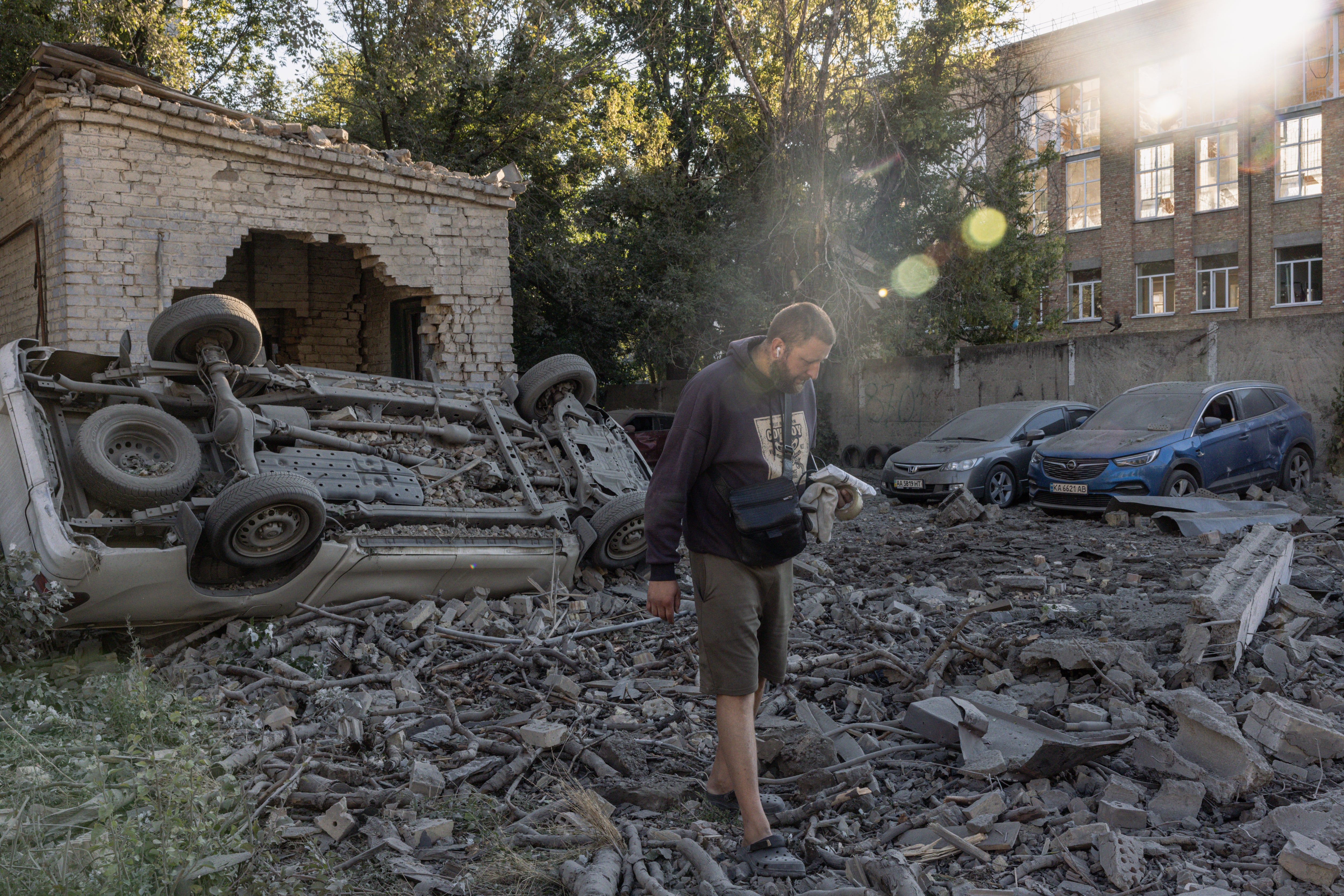 Residents walk through debris in a courtyard following a Russian missile strike on Thursday