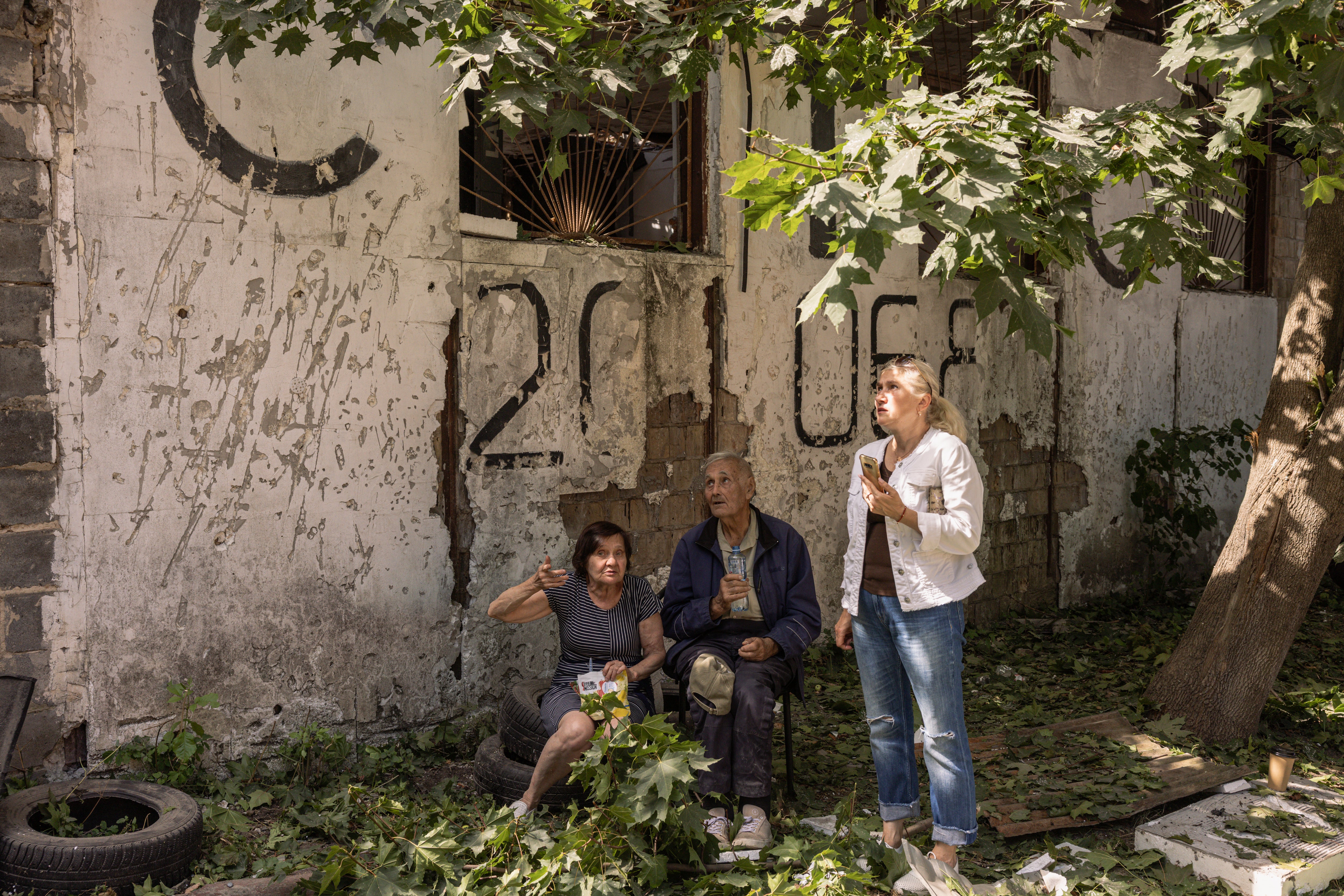 Locals gather outside a damaged apartment building in Kyiv