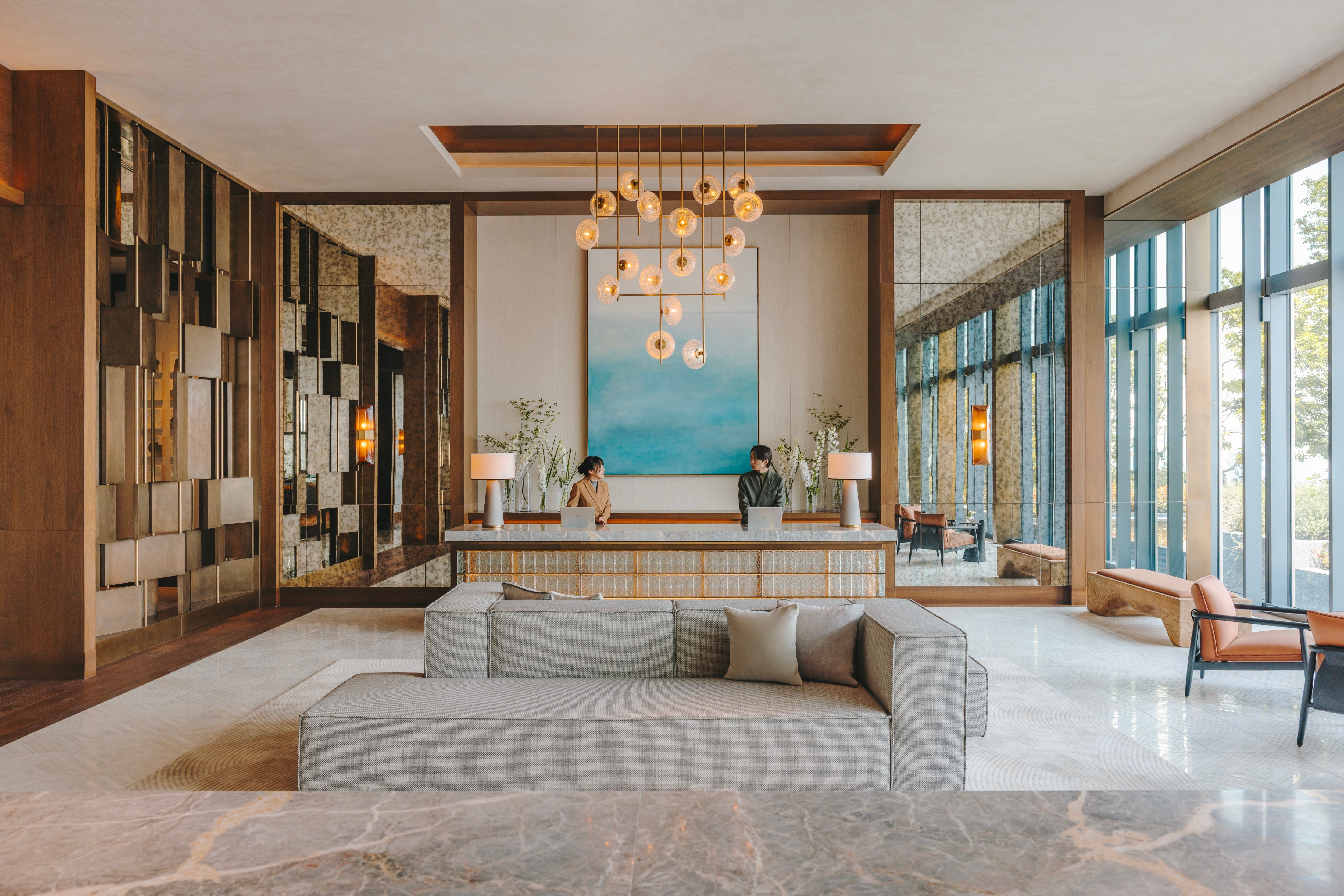 Floor-to-ceiling windows. and bespoke lighting creates an airy reception space