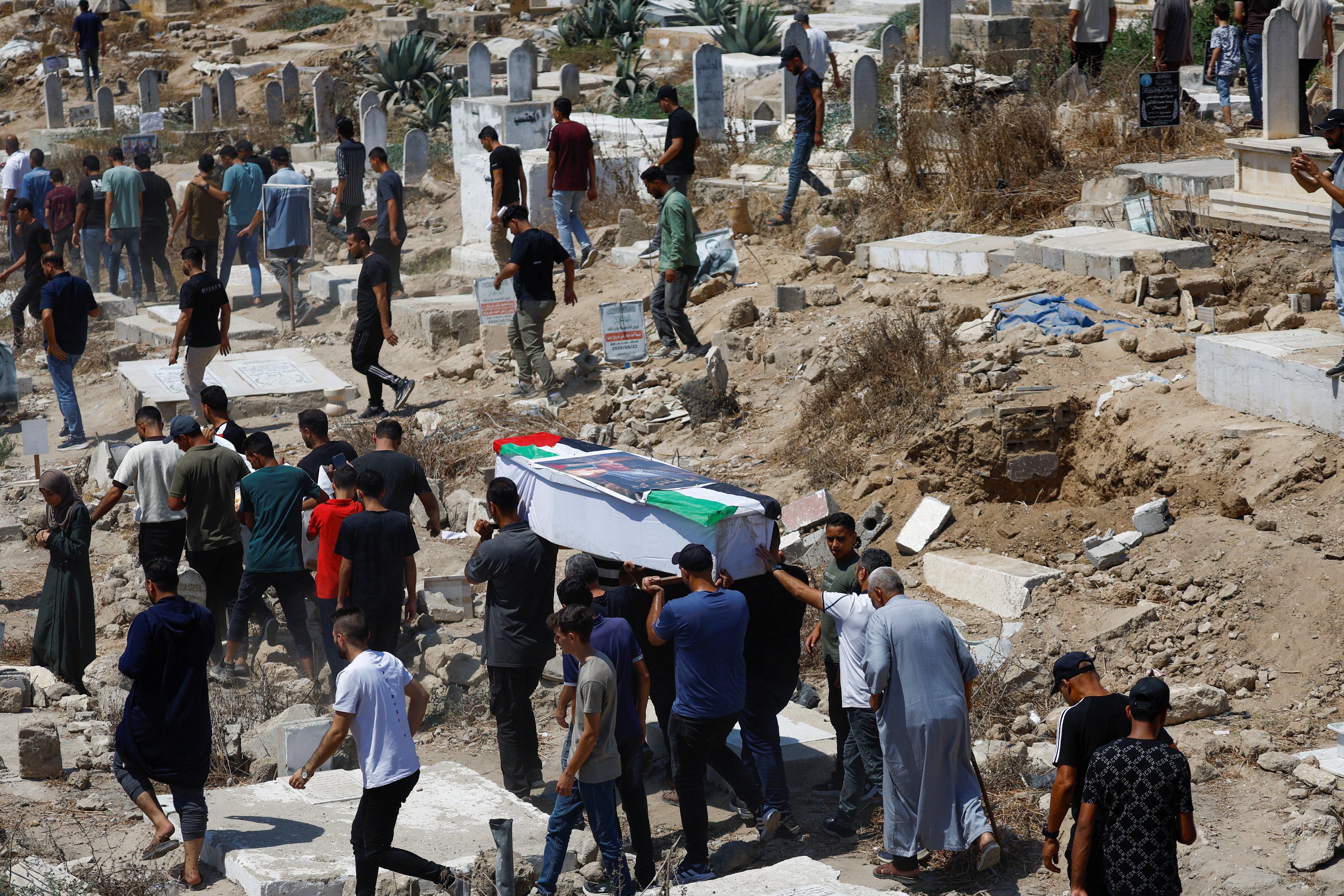 Palestinians carry a coffin during a mass funeral in Gaza City of 50 people whose bodies were recently retrieved from the rubble